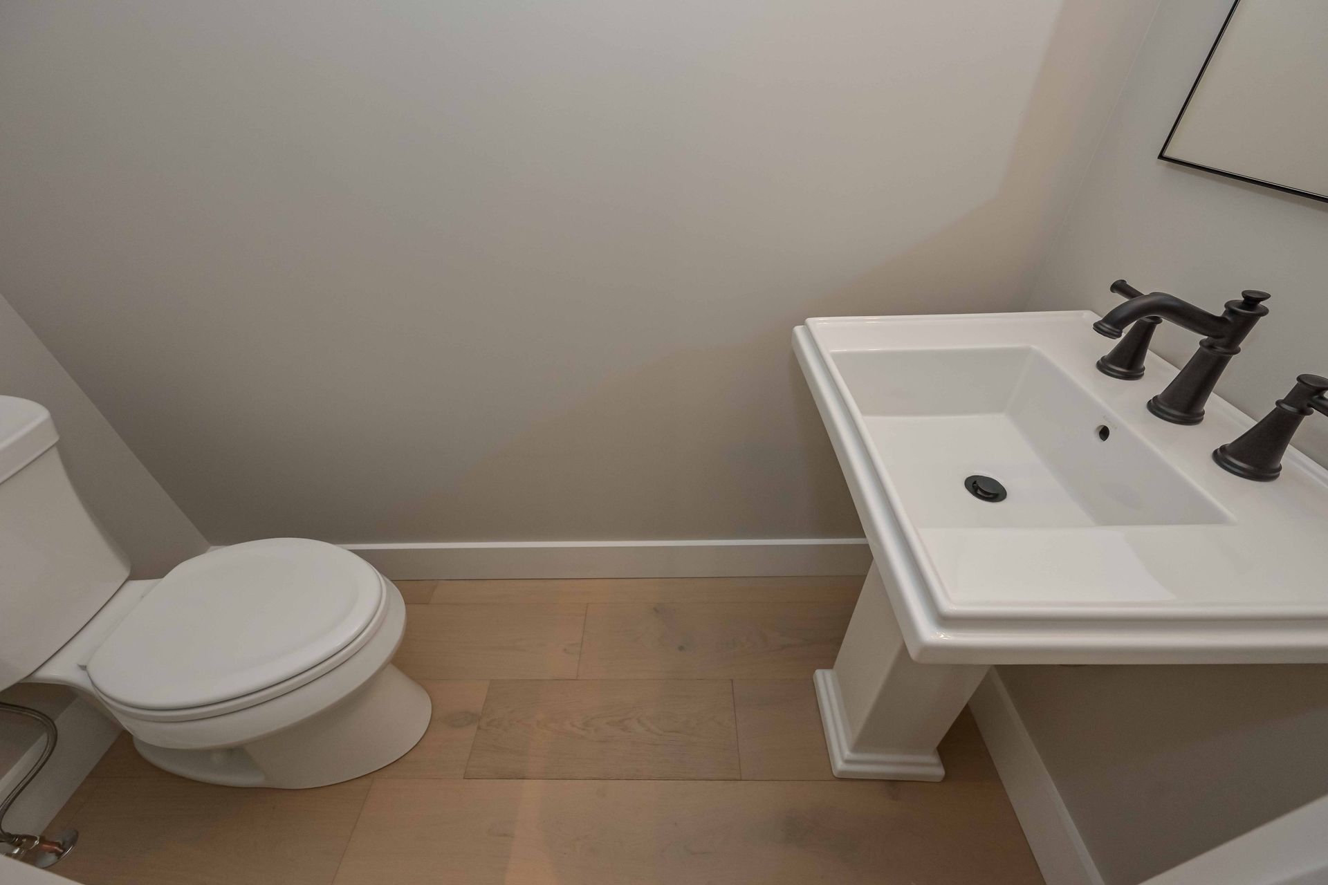 A bathroom with a toilet , sink and mirror.