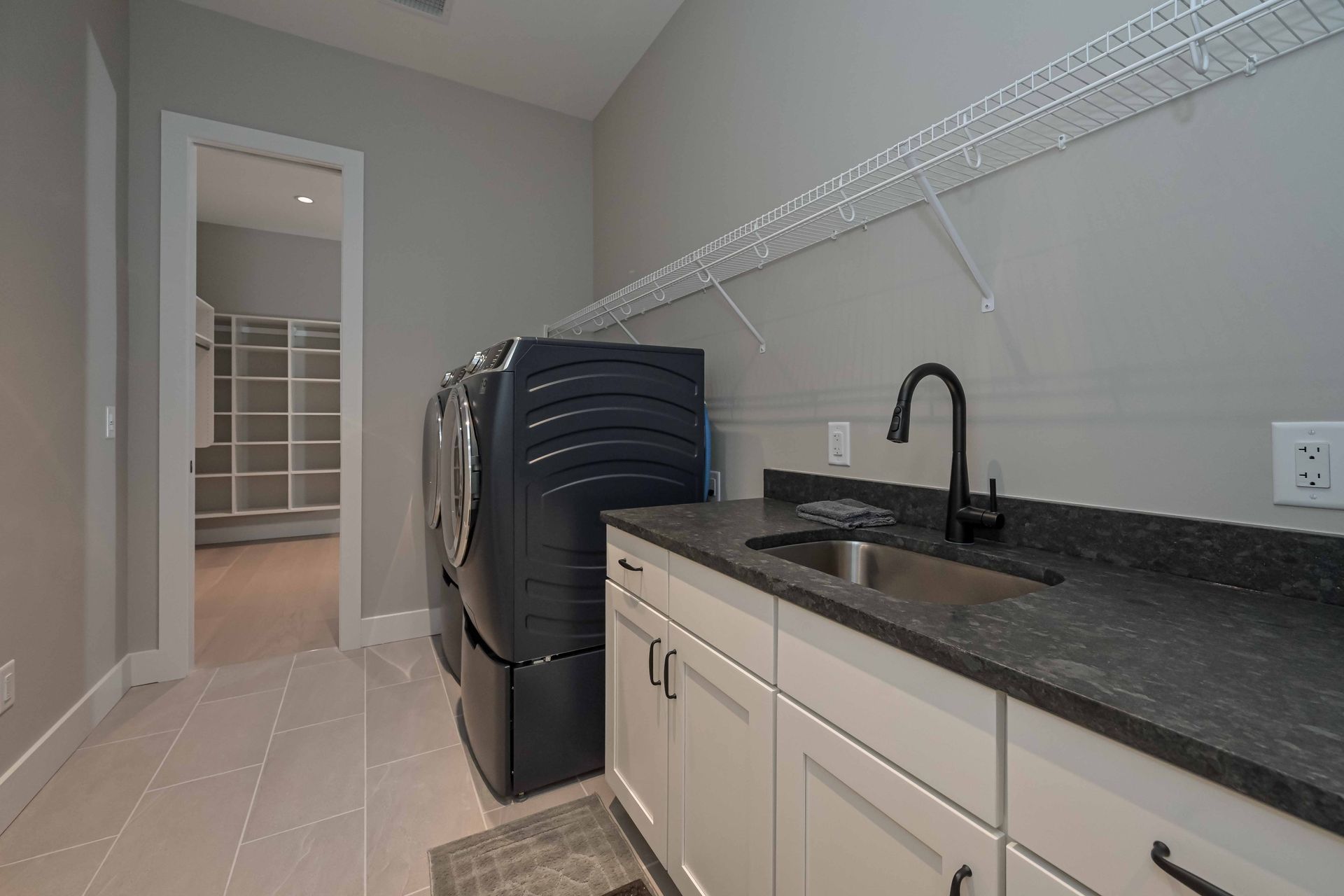 A laundry room with a washer and dryer and a sink.