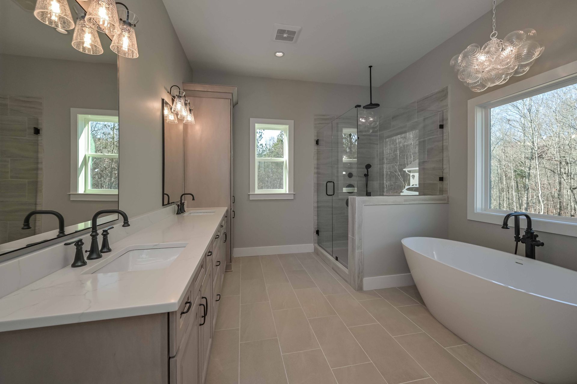A bathroom with two sinks , a tub , and a shower.
