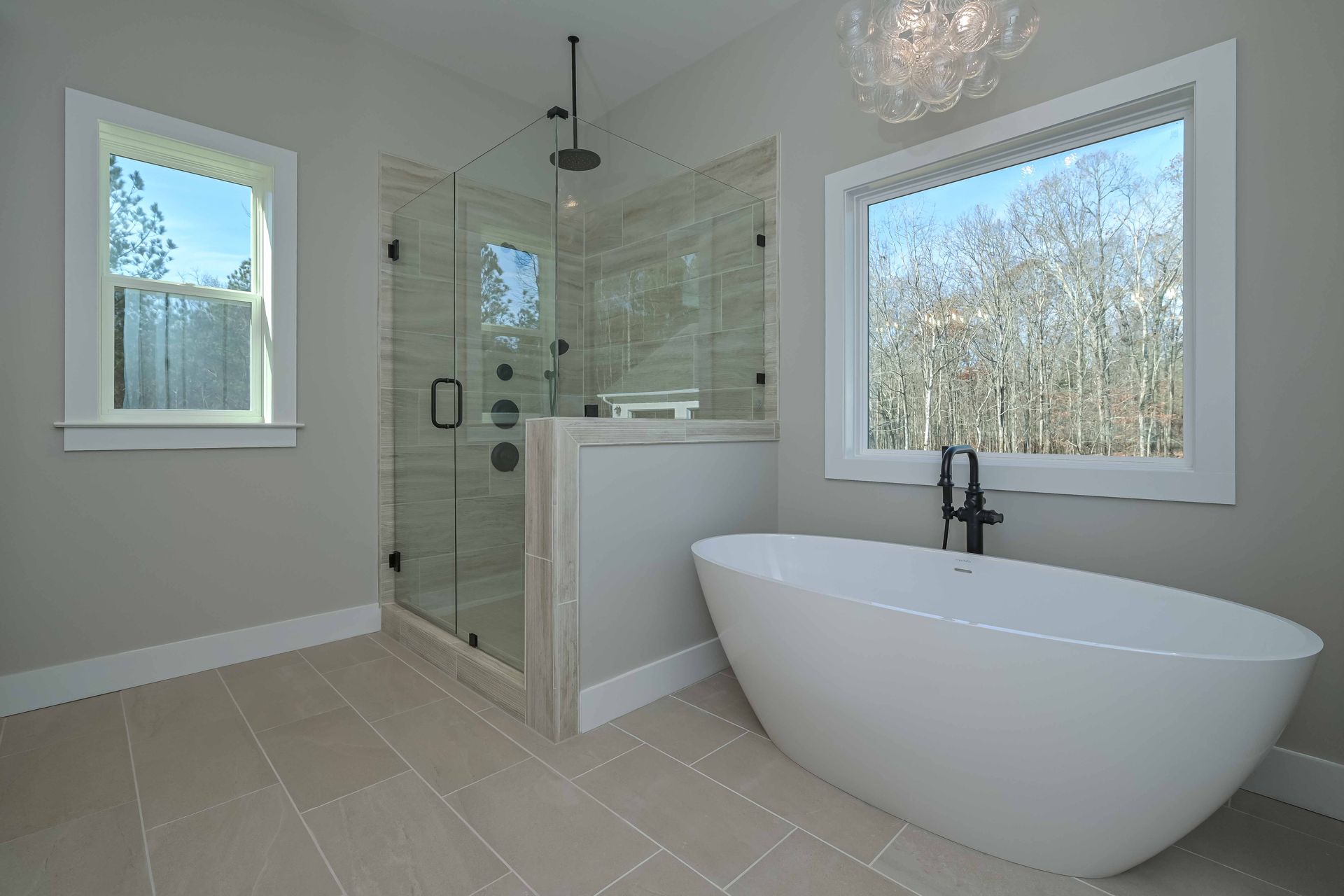 A bathroom with a tub , shower , and window.