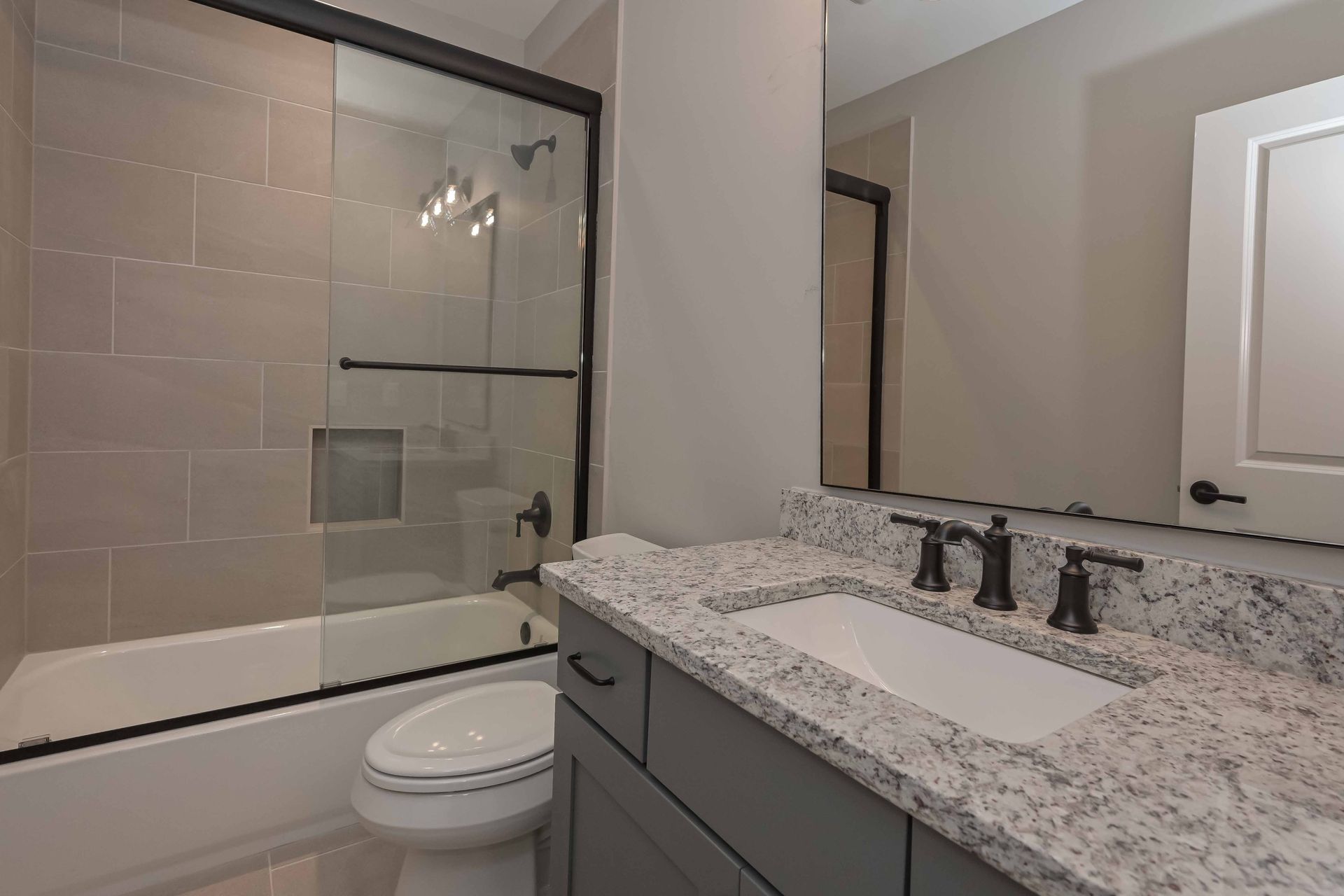 A bathroom with a toilet , sink , and bathtub.