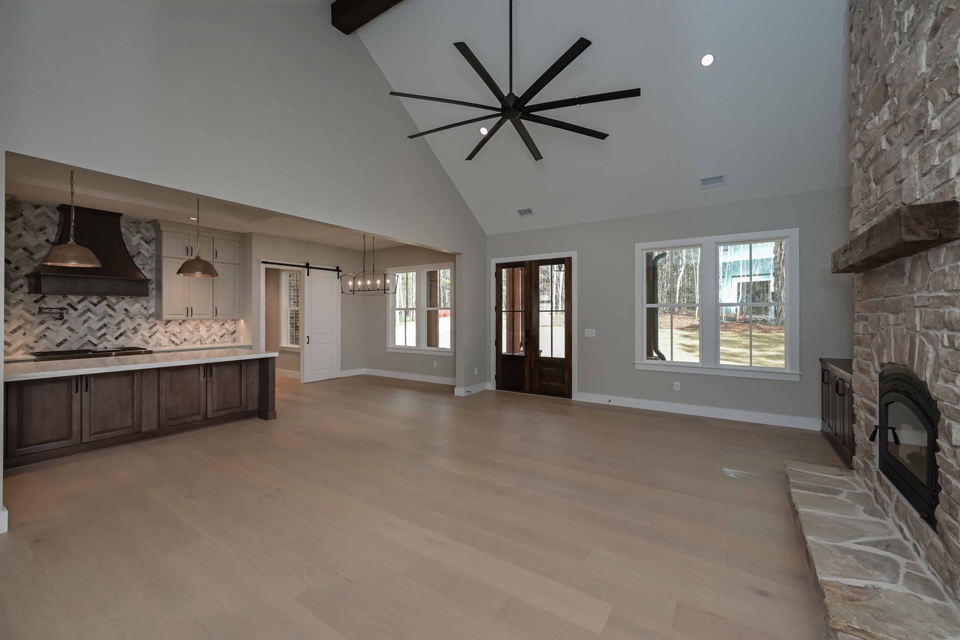 An empty living room with a ceiling fan and a fireplace.