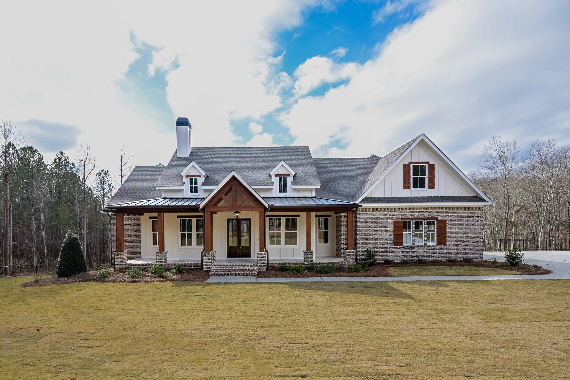 A large house is sitting in the middle of a grassy field.