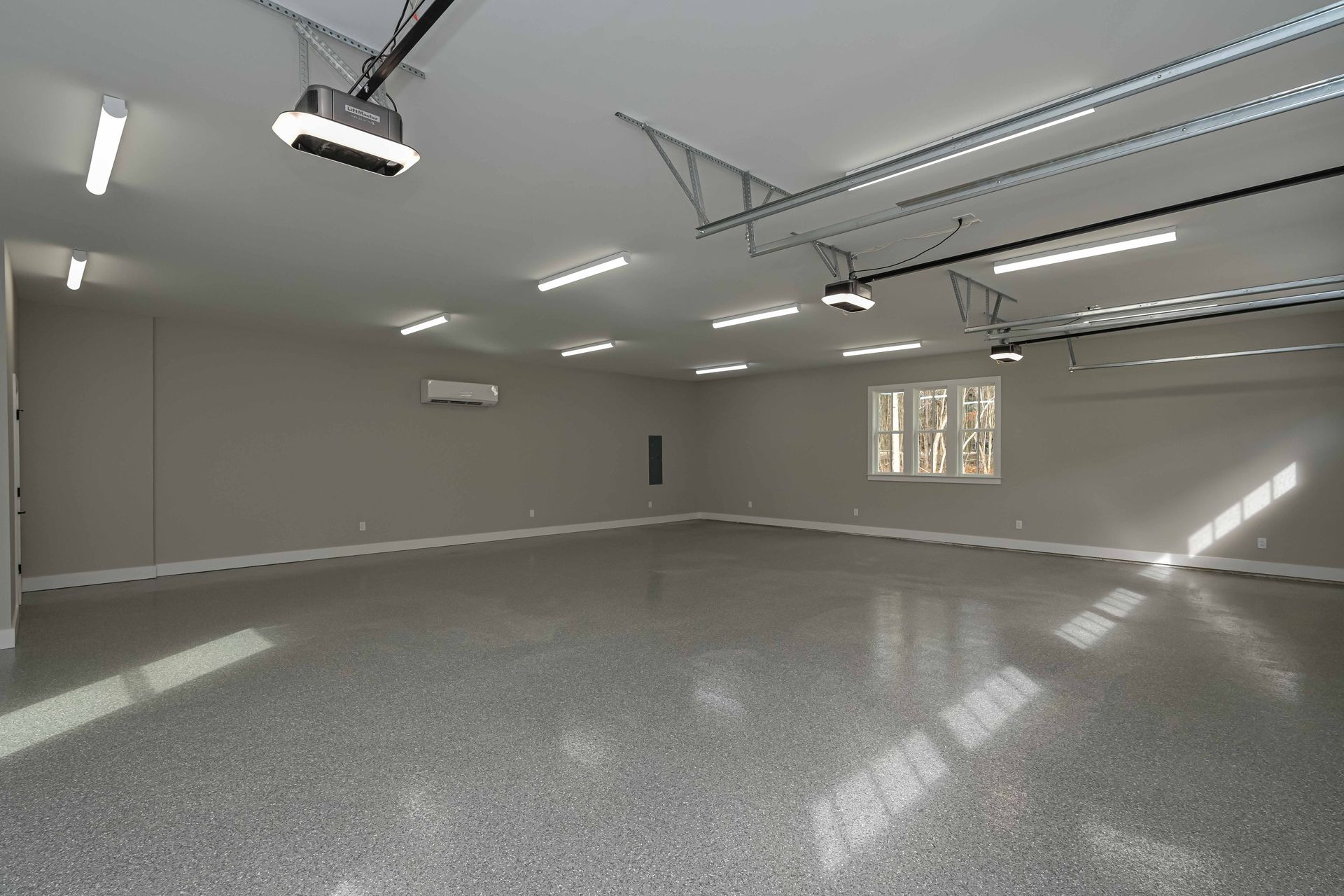 An empty garage with a ceiling fan and a garage door opener