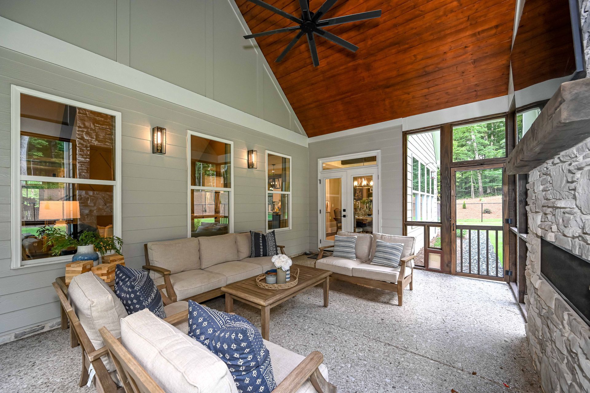 A living room with a couch , chairs , and a ceiling fan.
