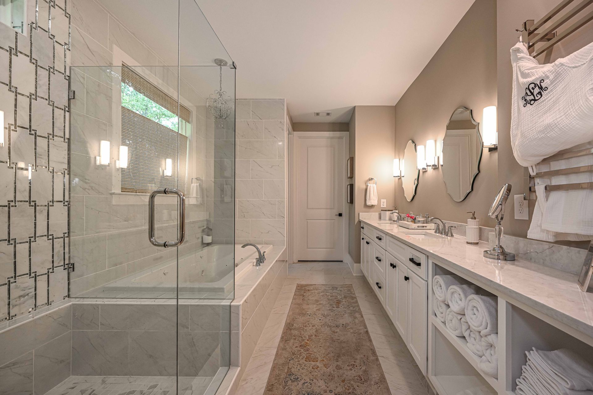 A bathroom with a walk in shower , tub , sinks and mirrors.