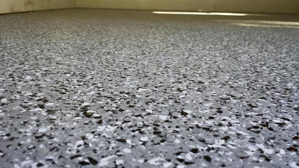 A close up of a gray and white marble floor in a garage