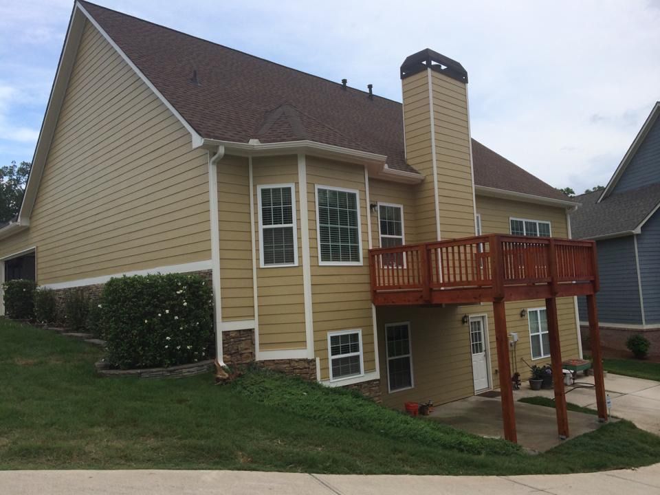 The back of a house with a deck and a chimney