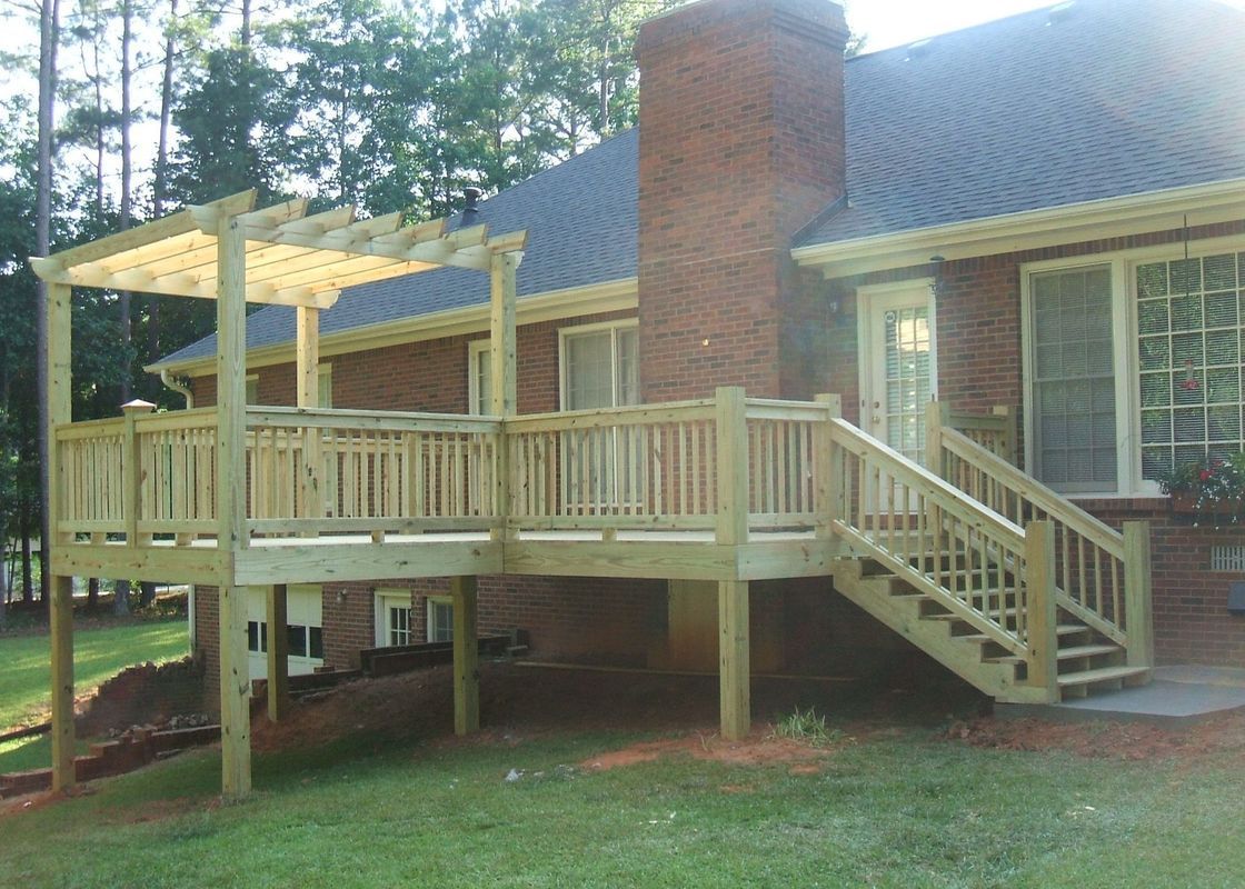 A brick house with a wooden deck and stairs