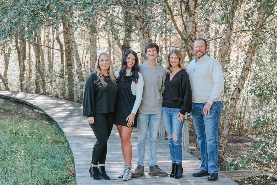 A man with a beard is wearing a vest with the word homes on it.