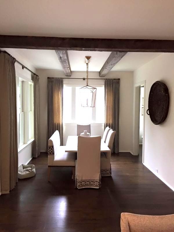 A dining room with a table and chairs in front of a window