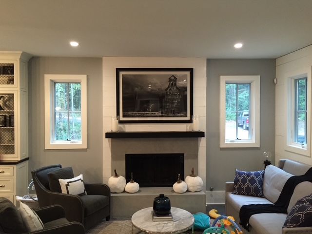 A living room with a fireplace and a couch and chairs