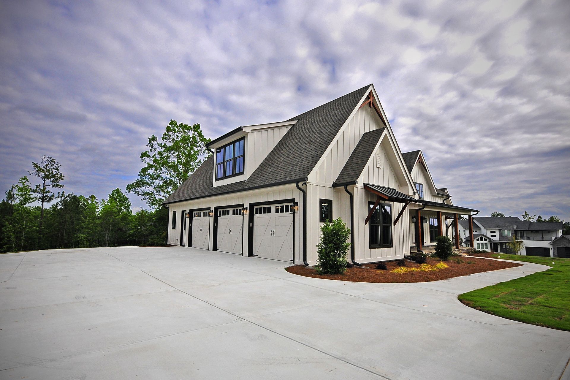 A large white house with a large driveway in front of it.