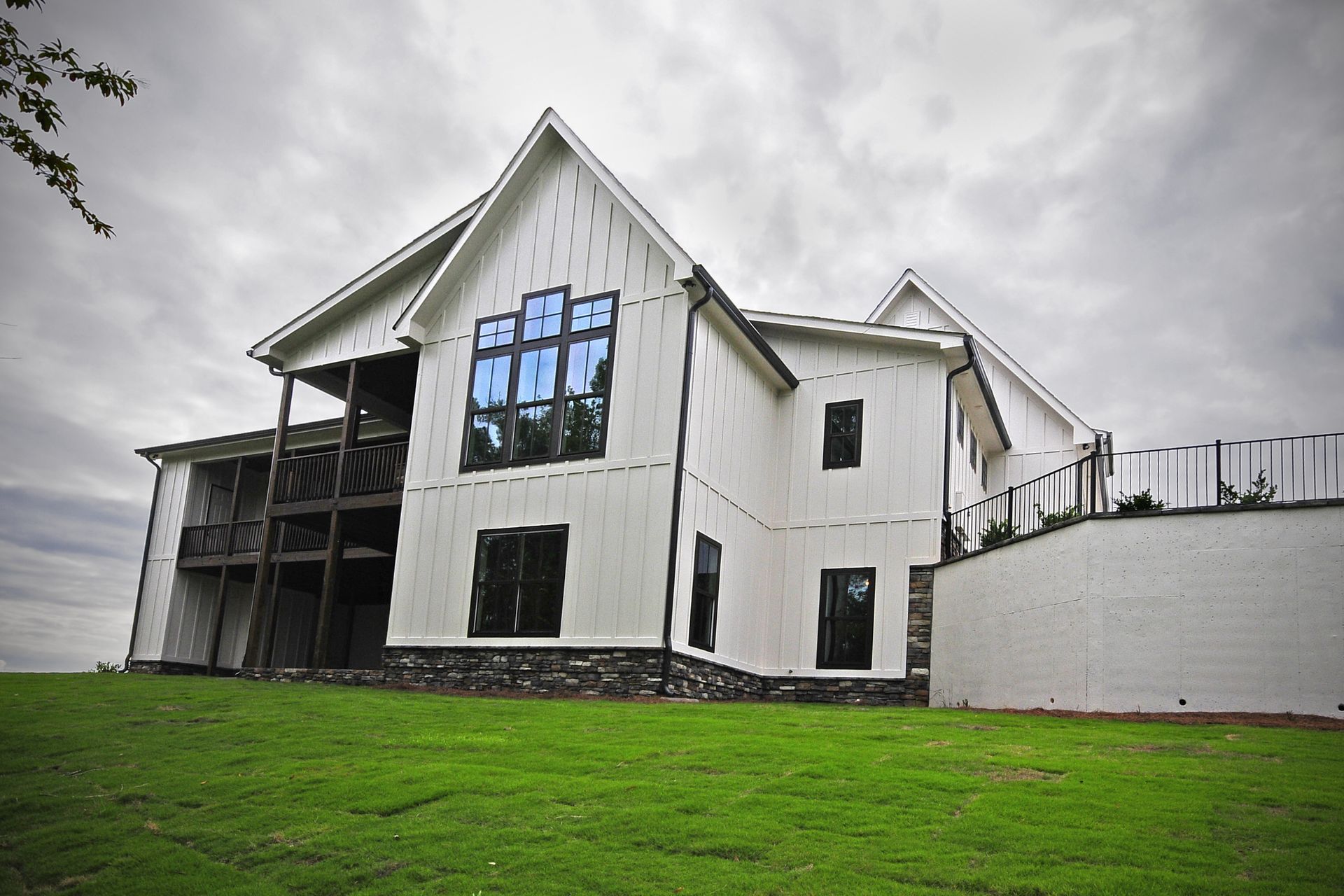 A large white house is sitting on top of a lush green hillside.