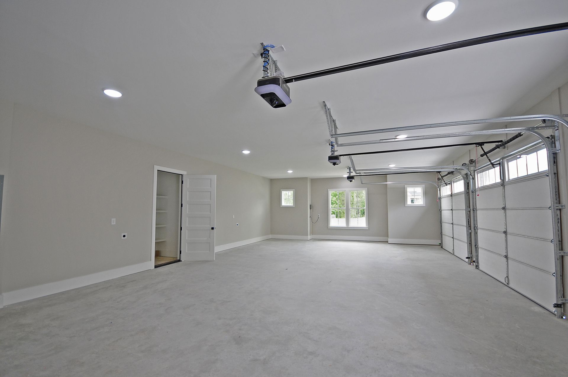 A large empty garage with a garage door open