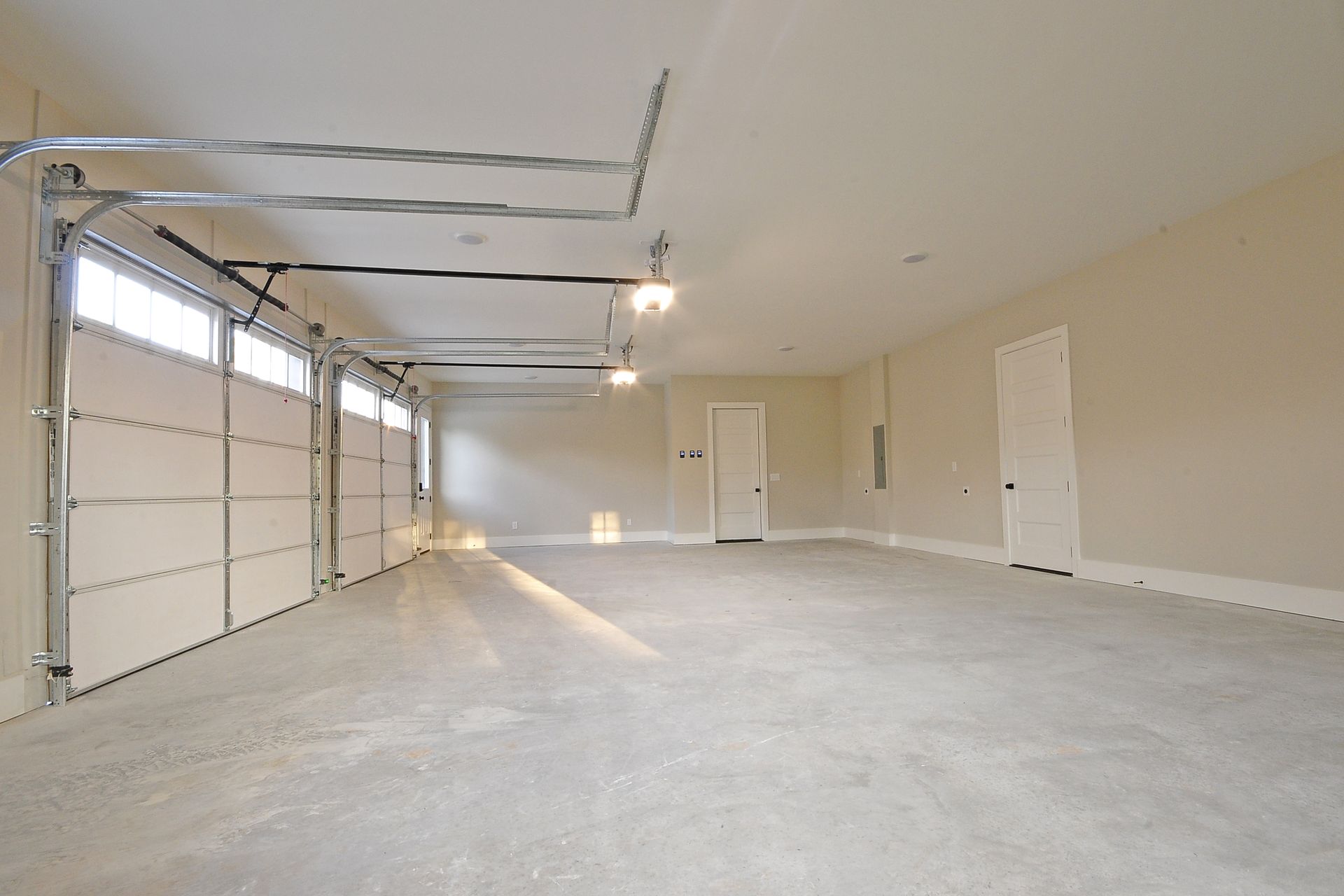 A large empty garage with two garage doors open