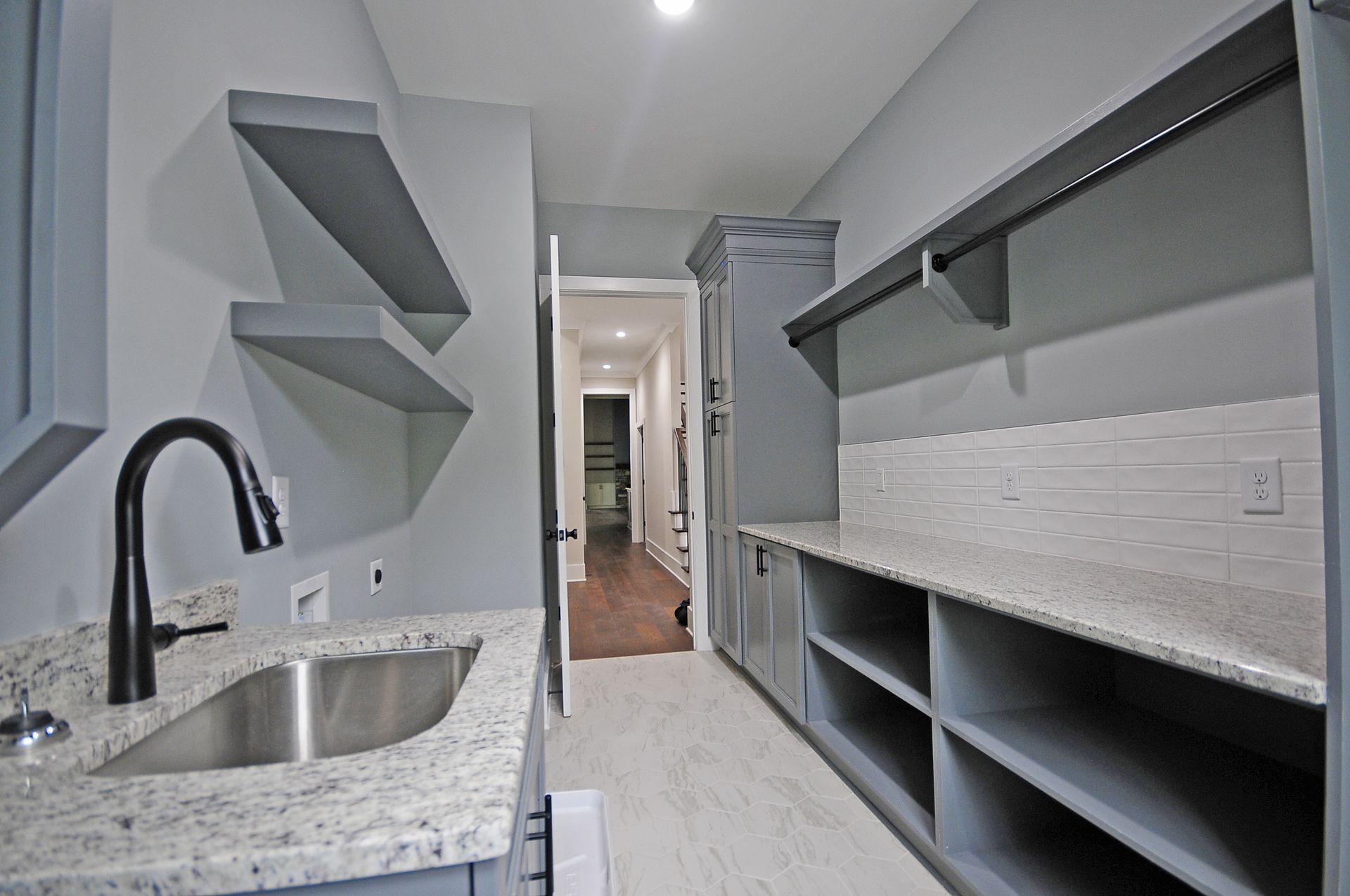 A kitchen with a stainless steel sink and granite counter tops
