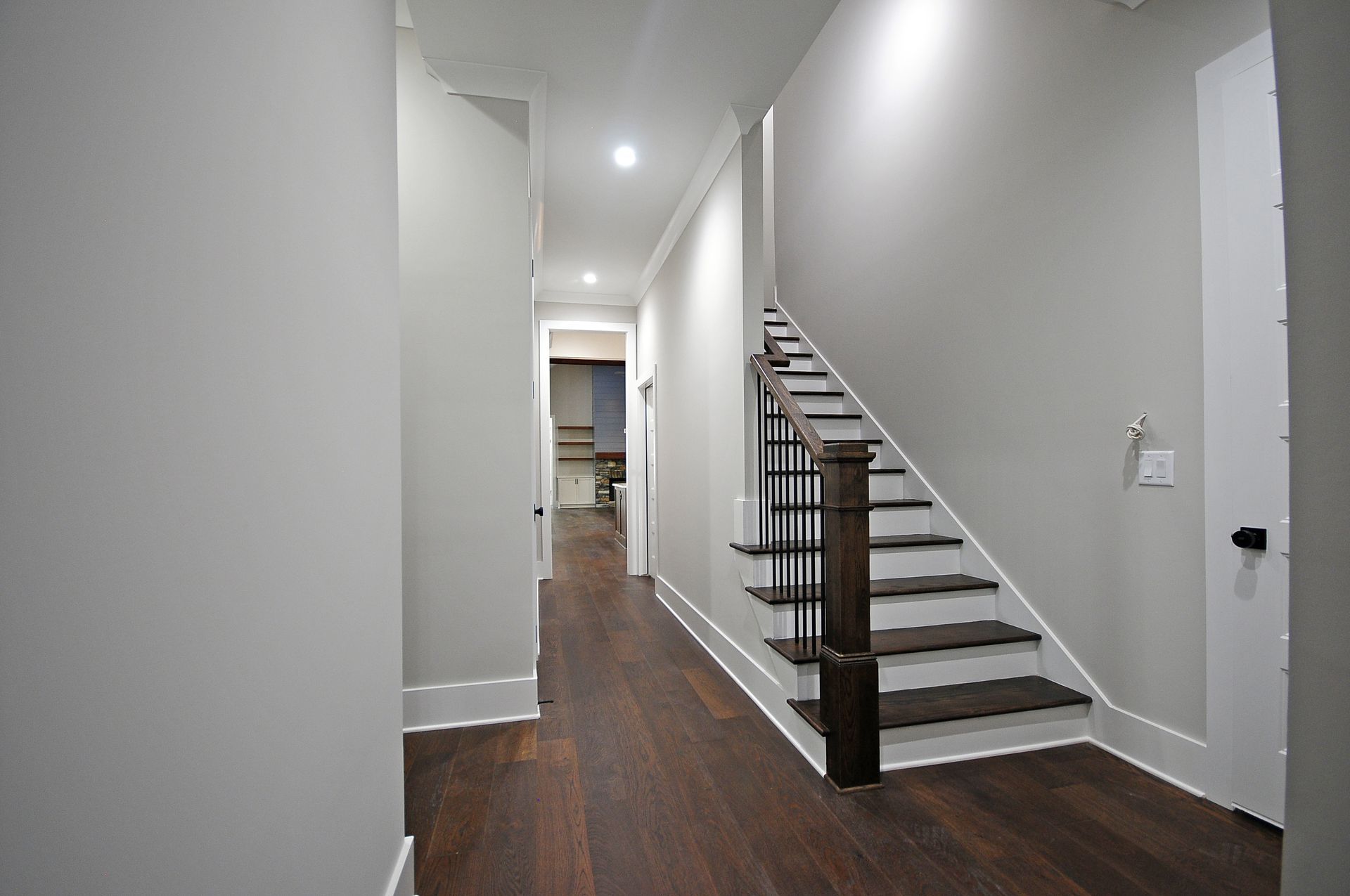 A hallway with stairs leading up to the second floor of a house.