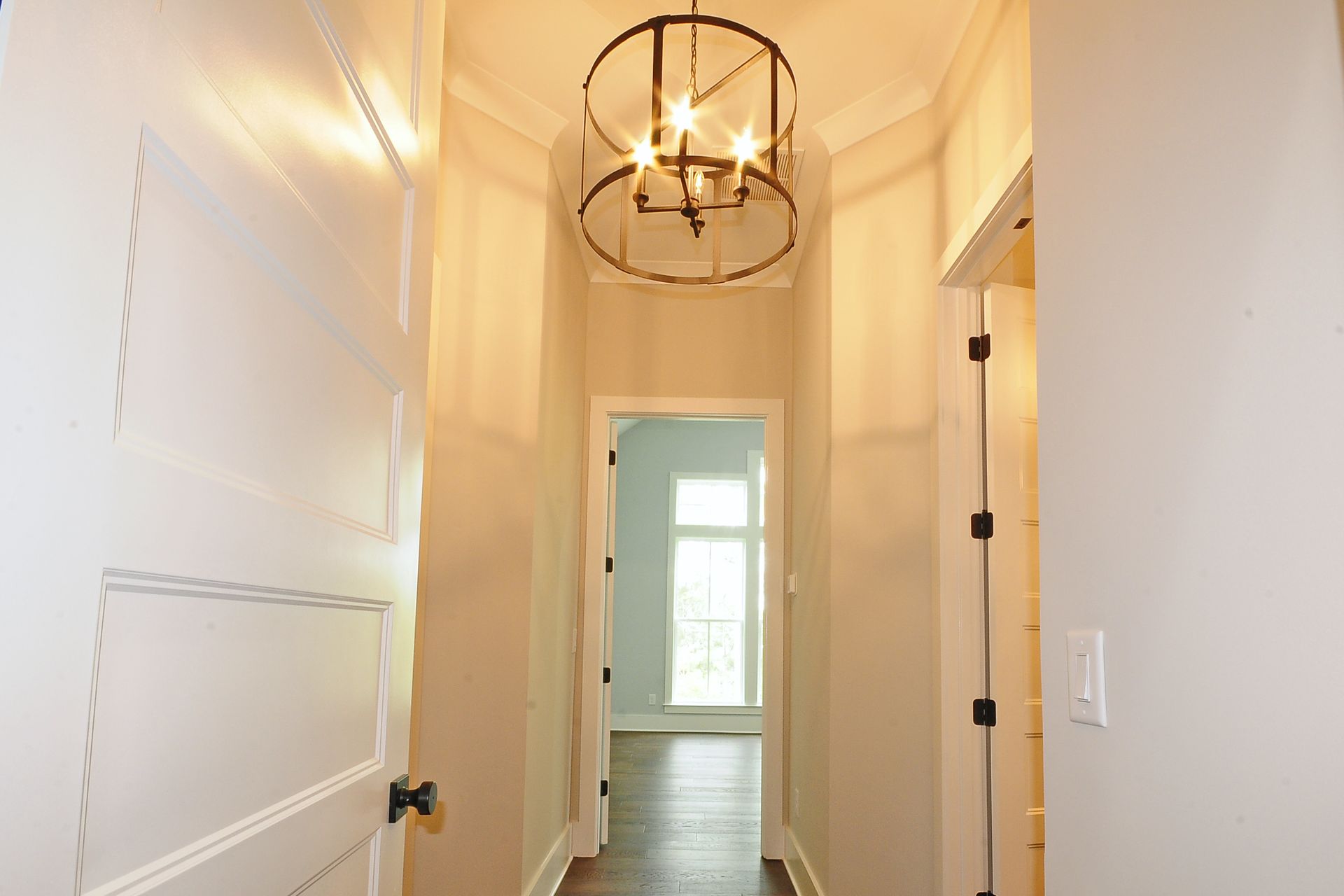 A hallway in a house with a chandelier hanging from the ceiling.