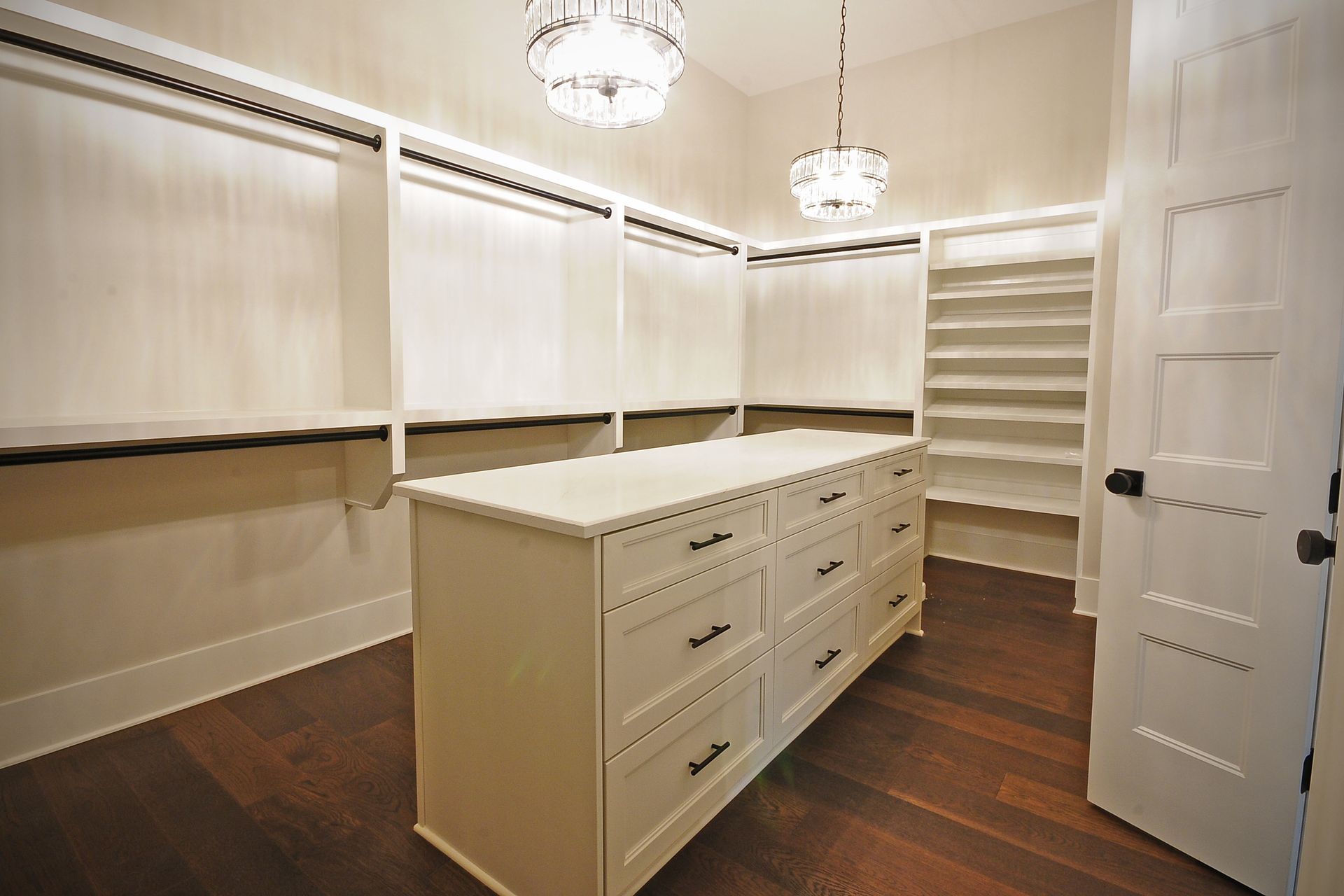 A walk in closet with a large island in the middle.