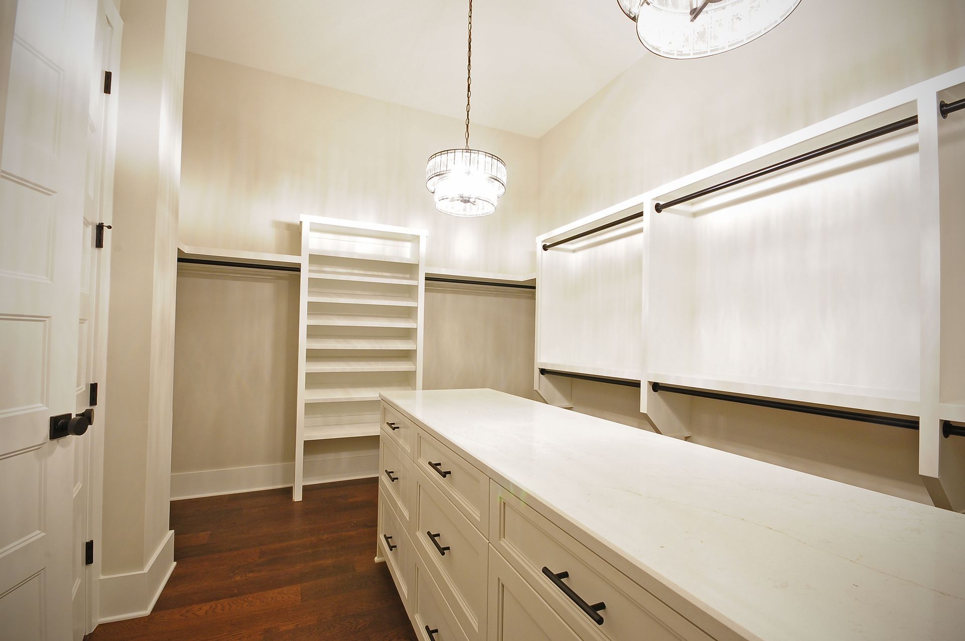 A walk in closet with lots of shelves and drawers