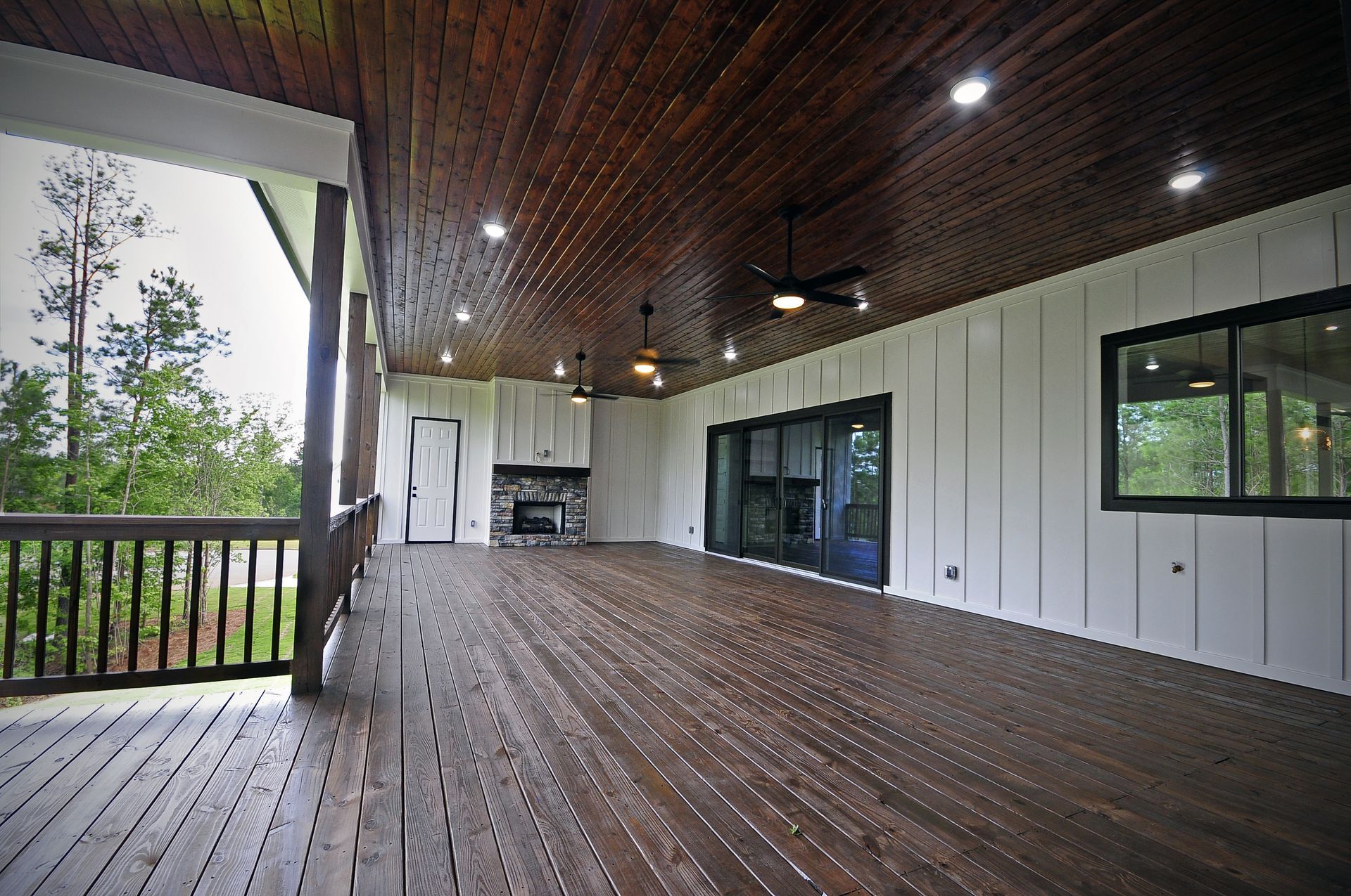 A large deck with a ceiling fan and a fireplace