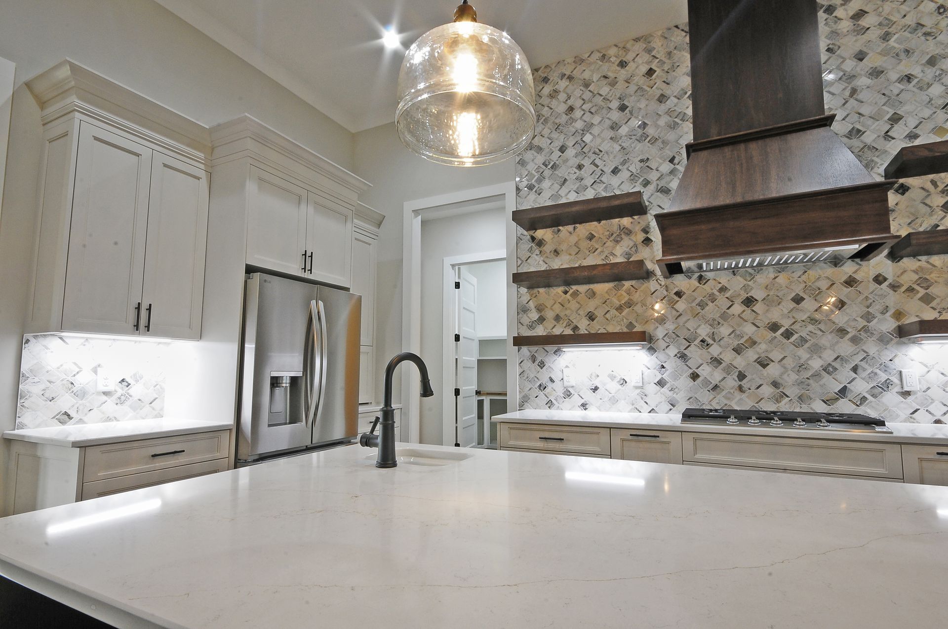 A kitchen with white cabinets , stainless steel appliances , and a large island.