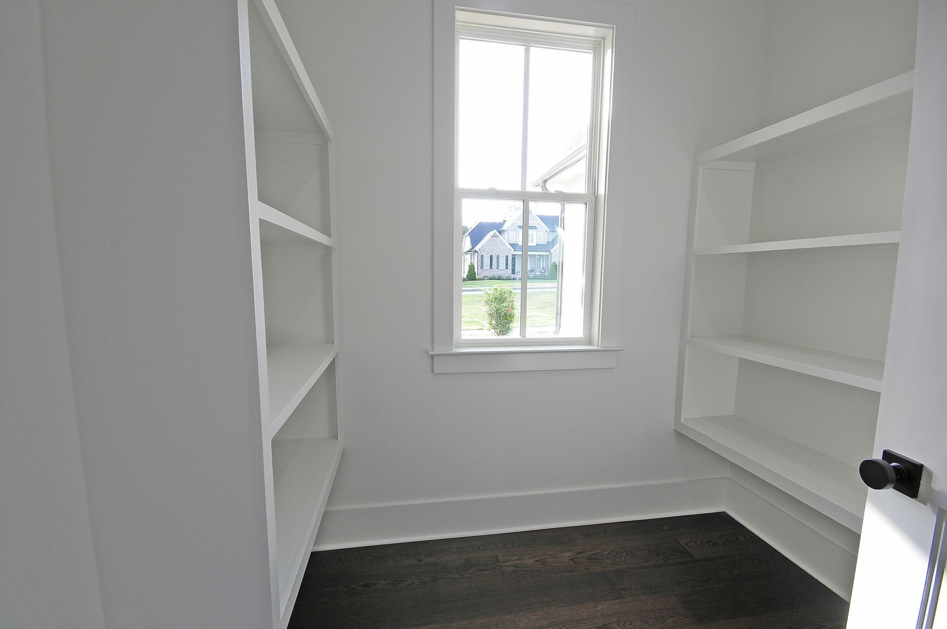 An empty room with shelves and a window.