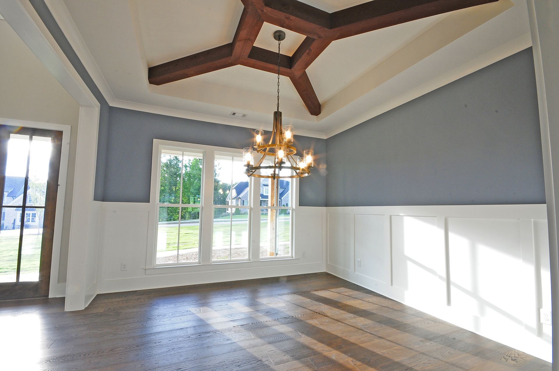 An empty room with a chandelier hanging from the ceiling