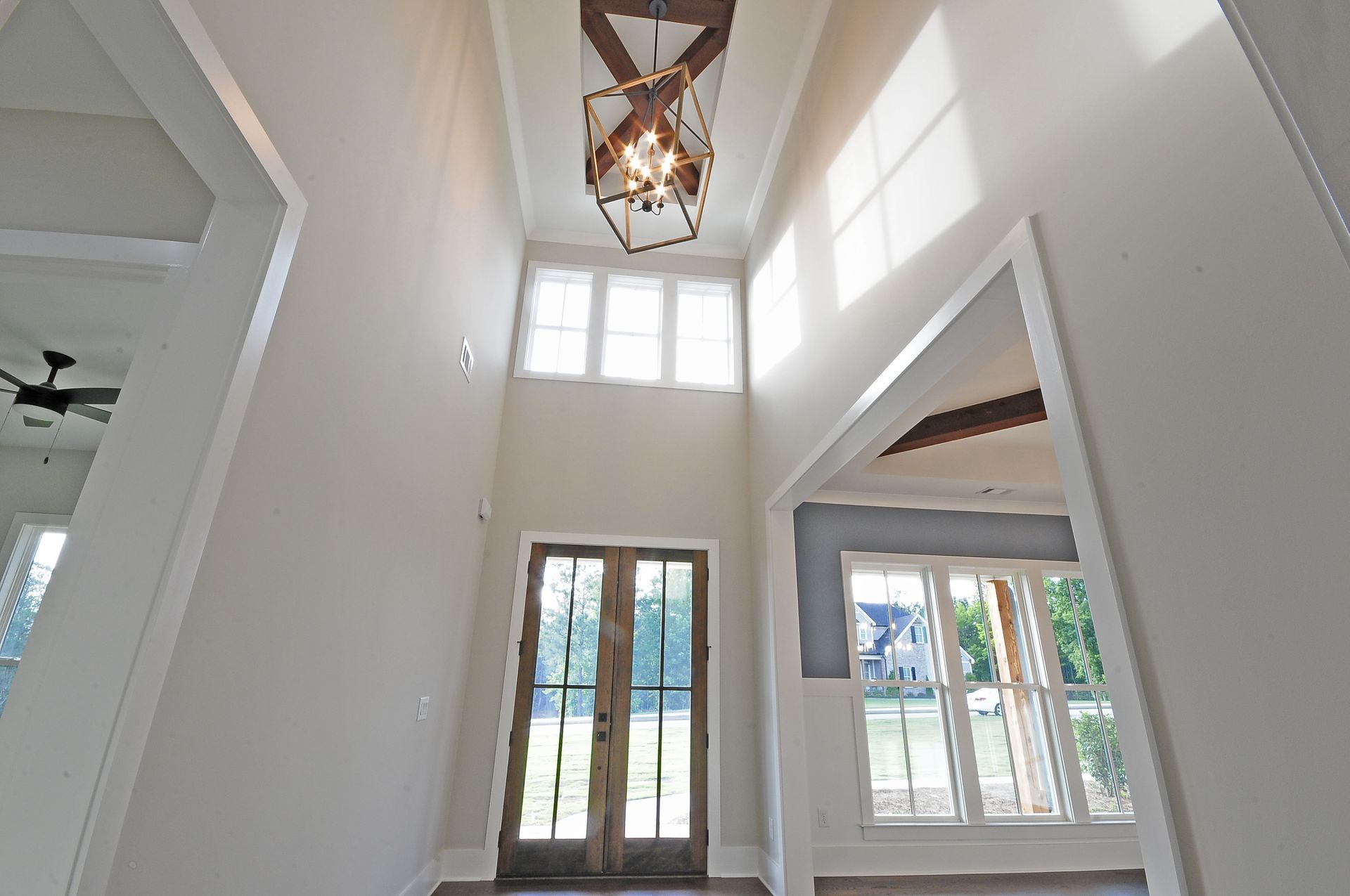A large empty room with a chandelier hanging from the ceiling.
