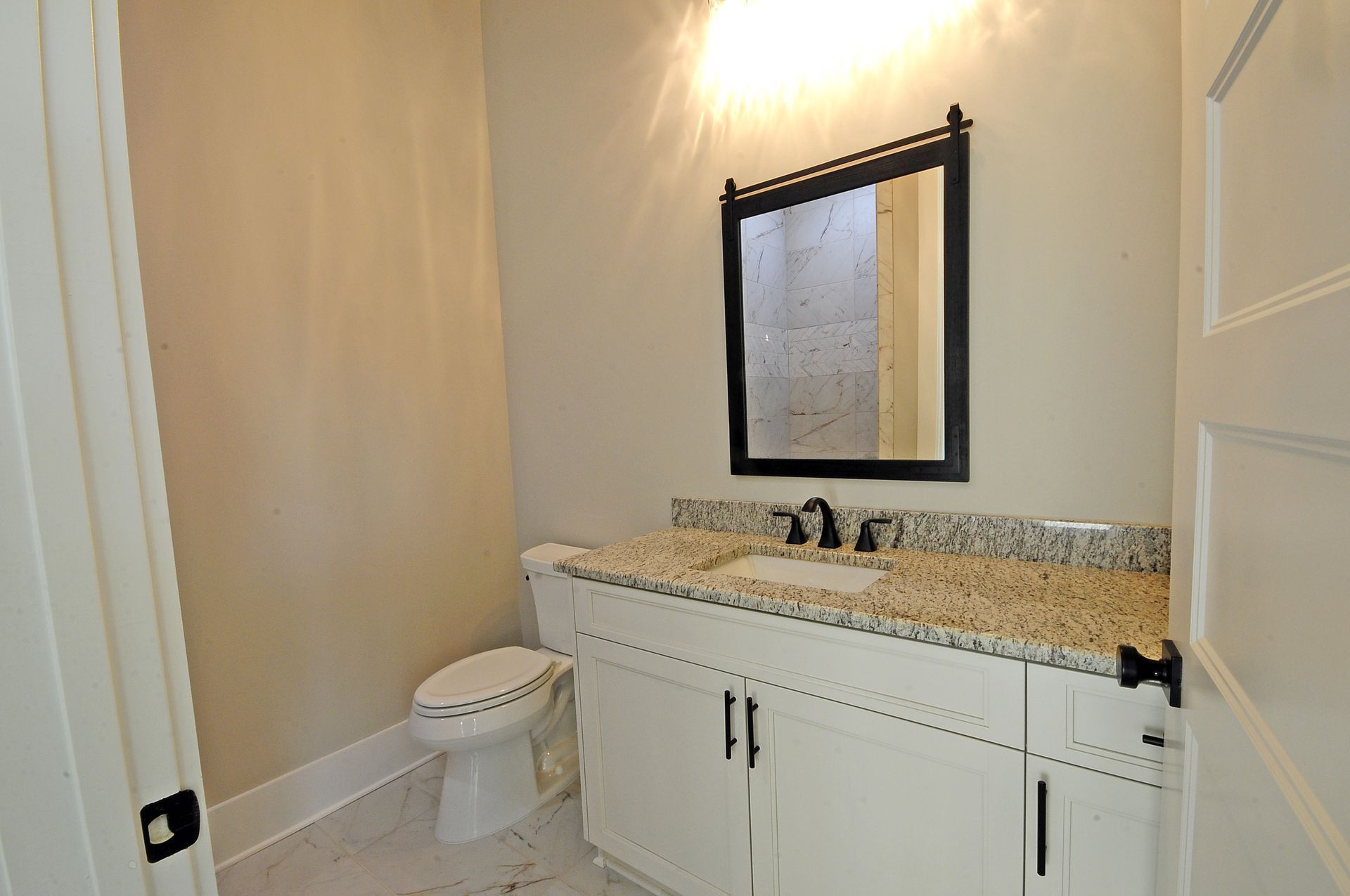 A bathroom with a toilet , sink and mirror
