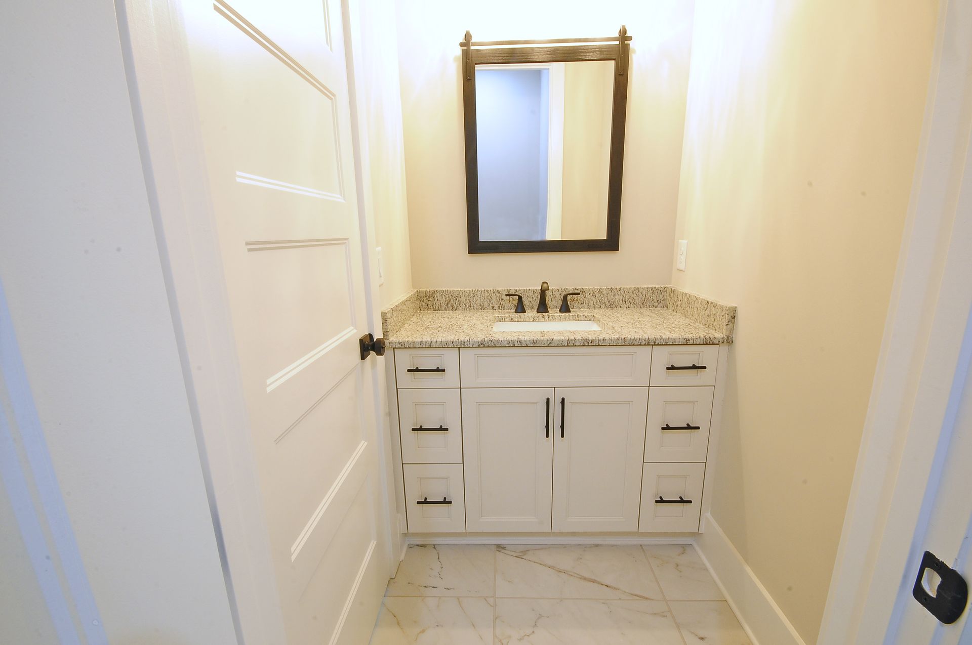 A bathroom with a sink , mirror and cabinets.