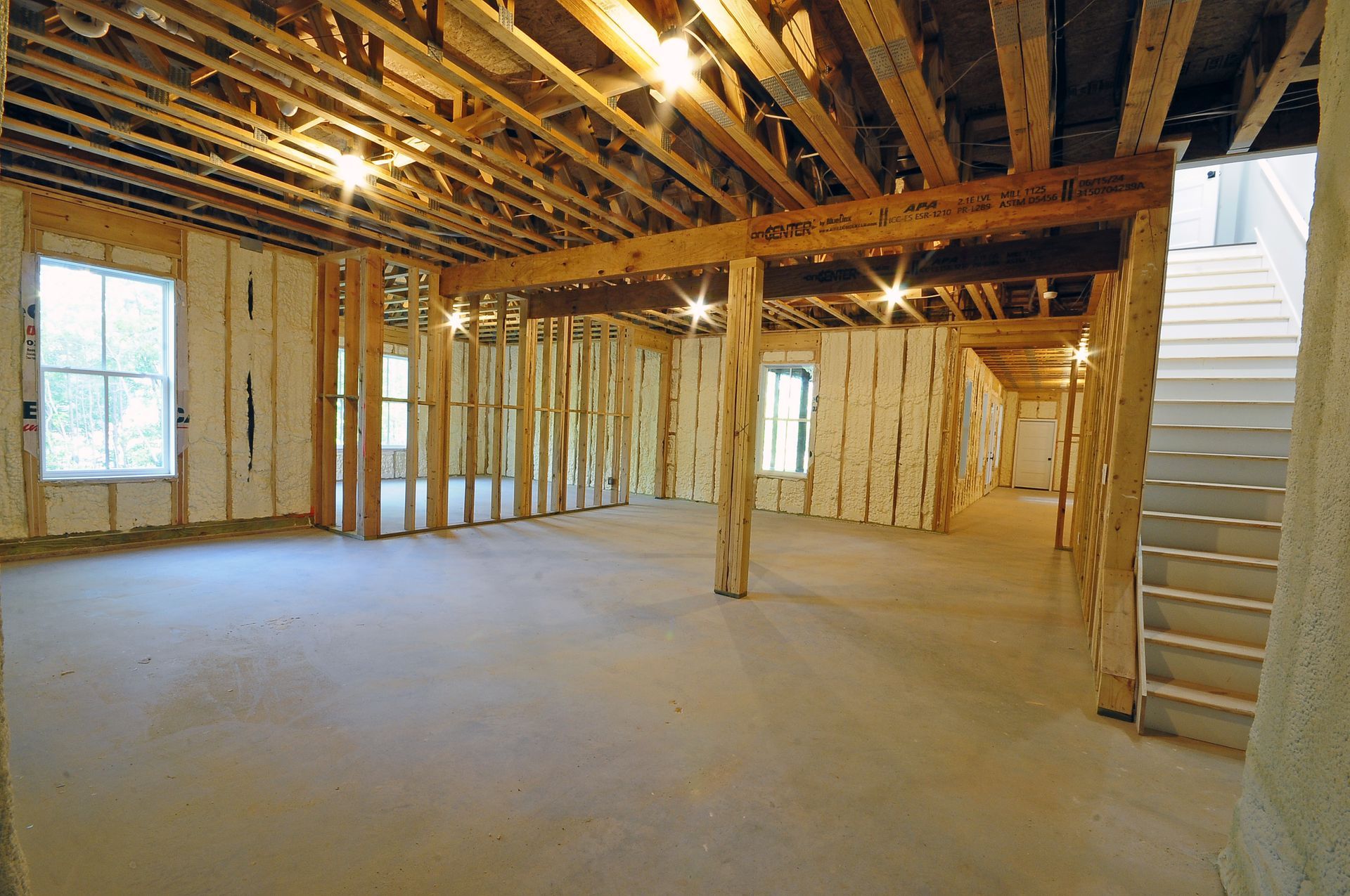 An empty room with wooden beams and stairs