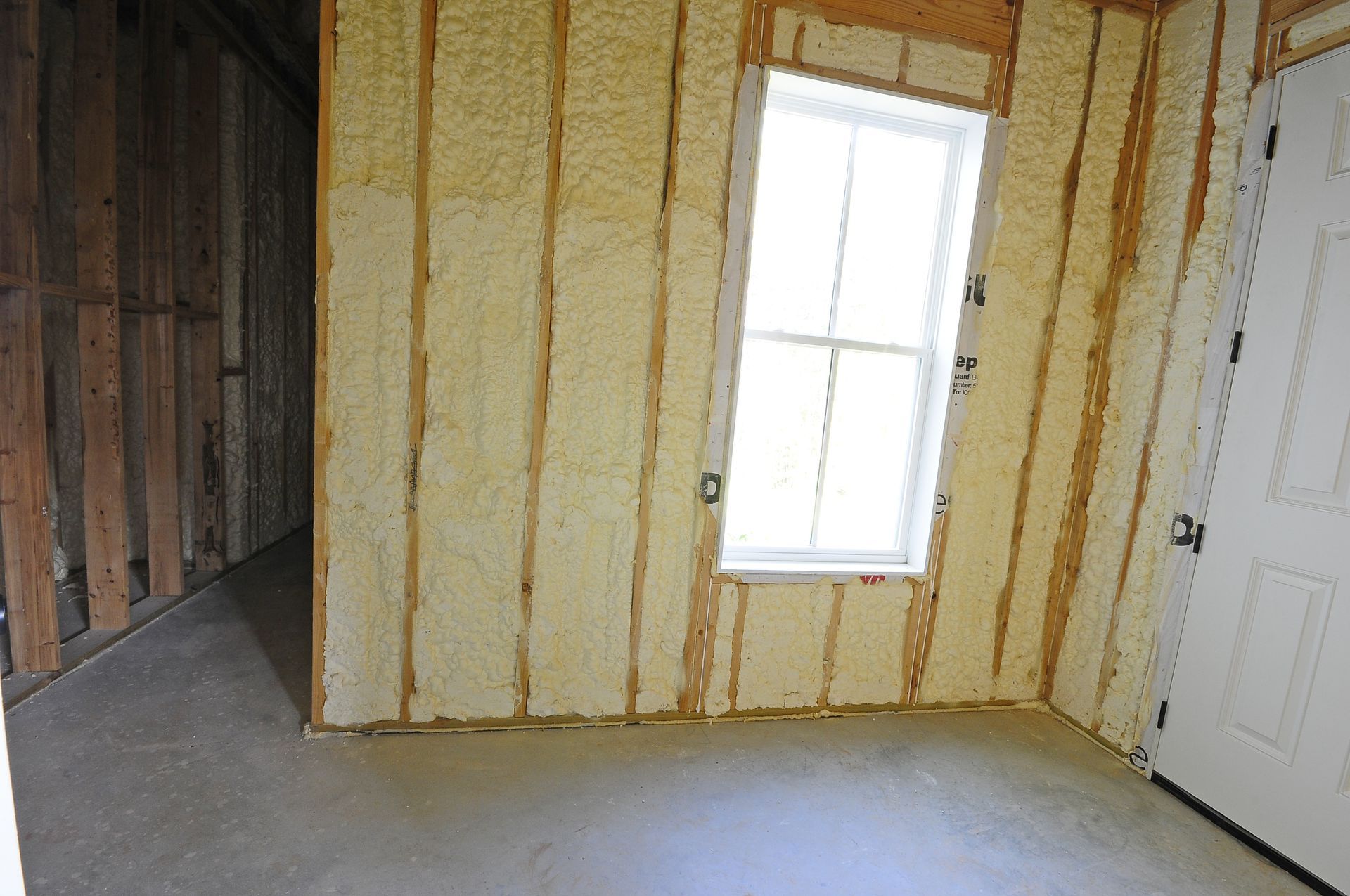 A room with foam insulation on the walls and a window