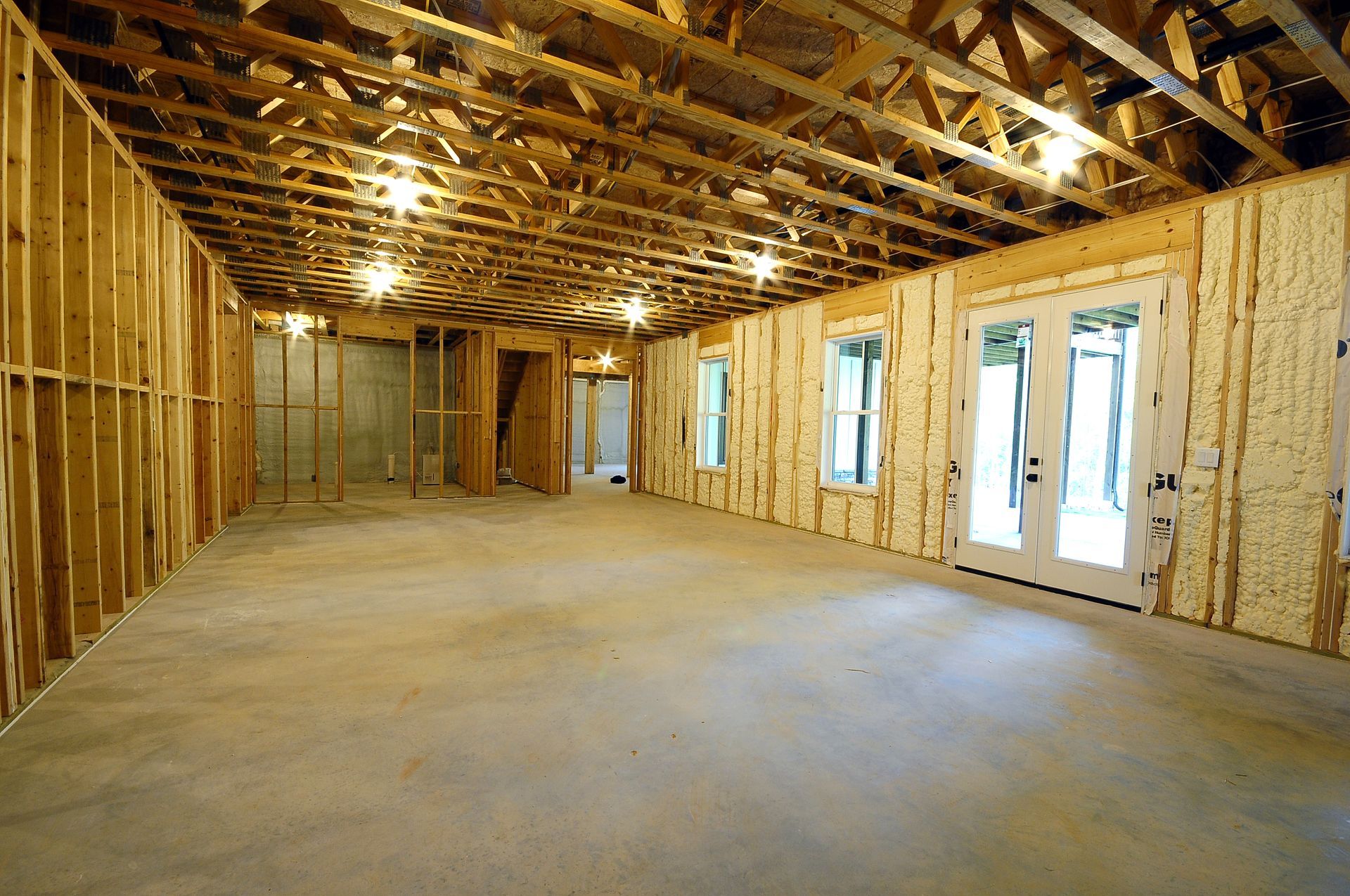 A large empty room with a lot of windows and doors