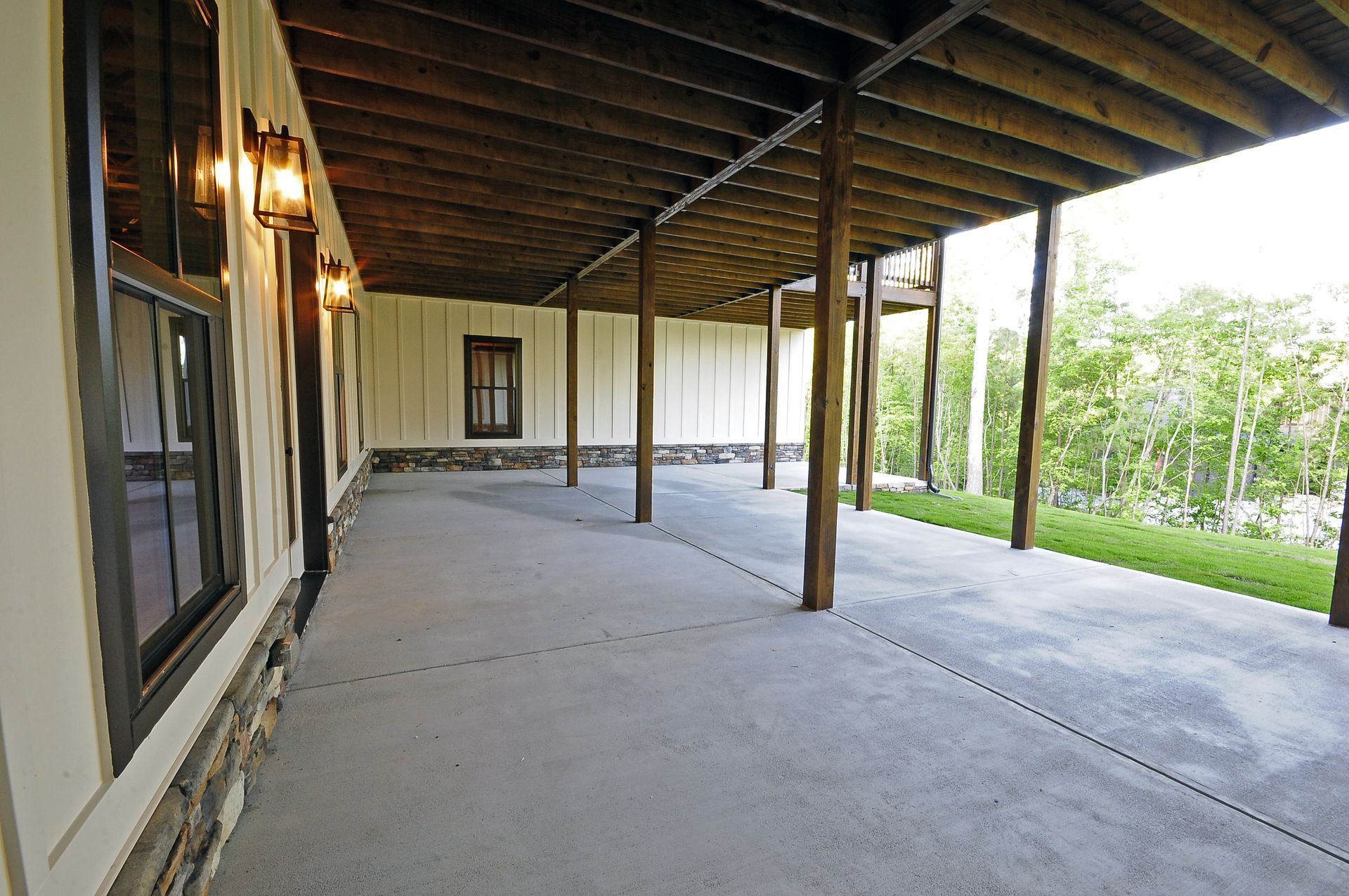 An empty porch with a wooden ceiling and a concrete floor
