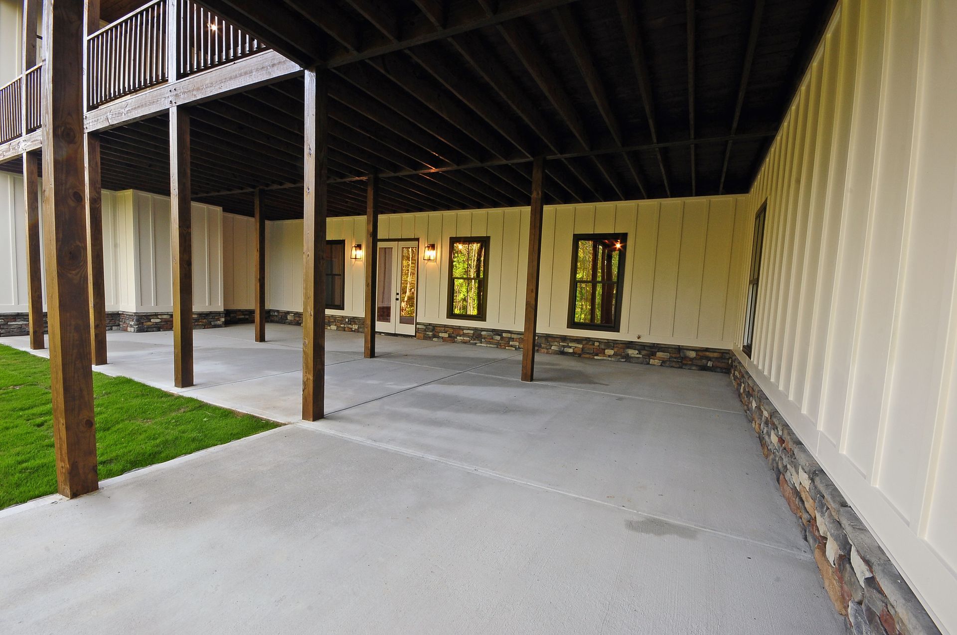A large patio with a wooden deck and a concrete floor