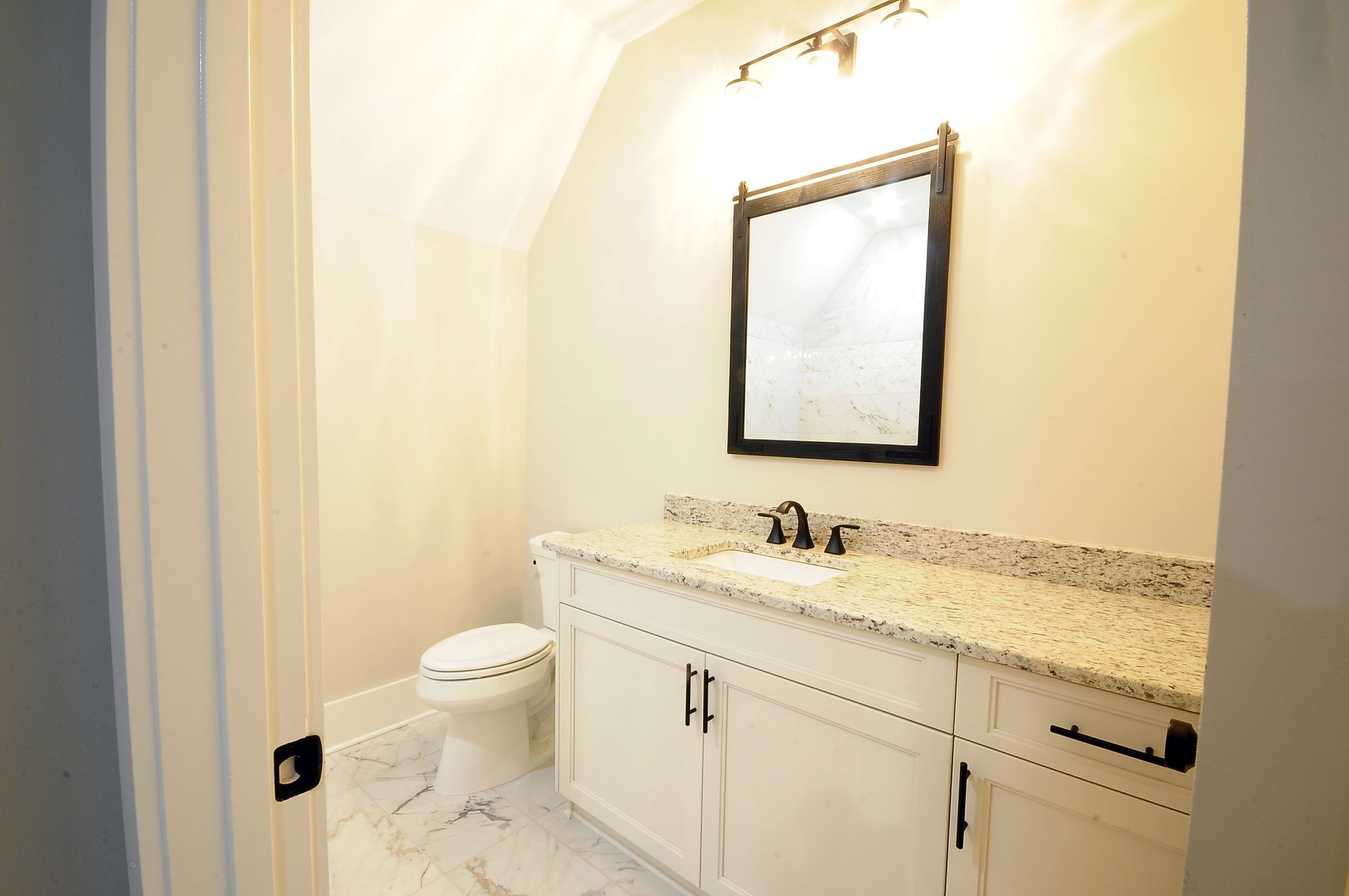 A bathroom with a sink , toilet and mirror.