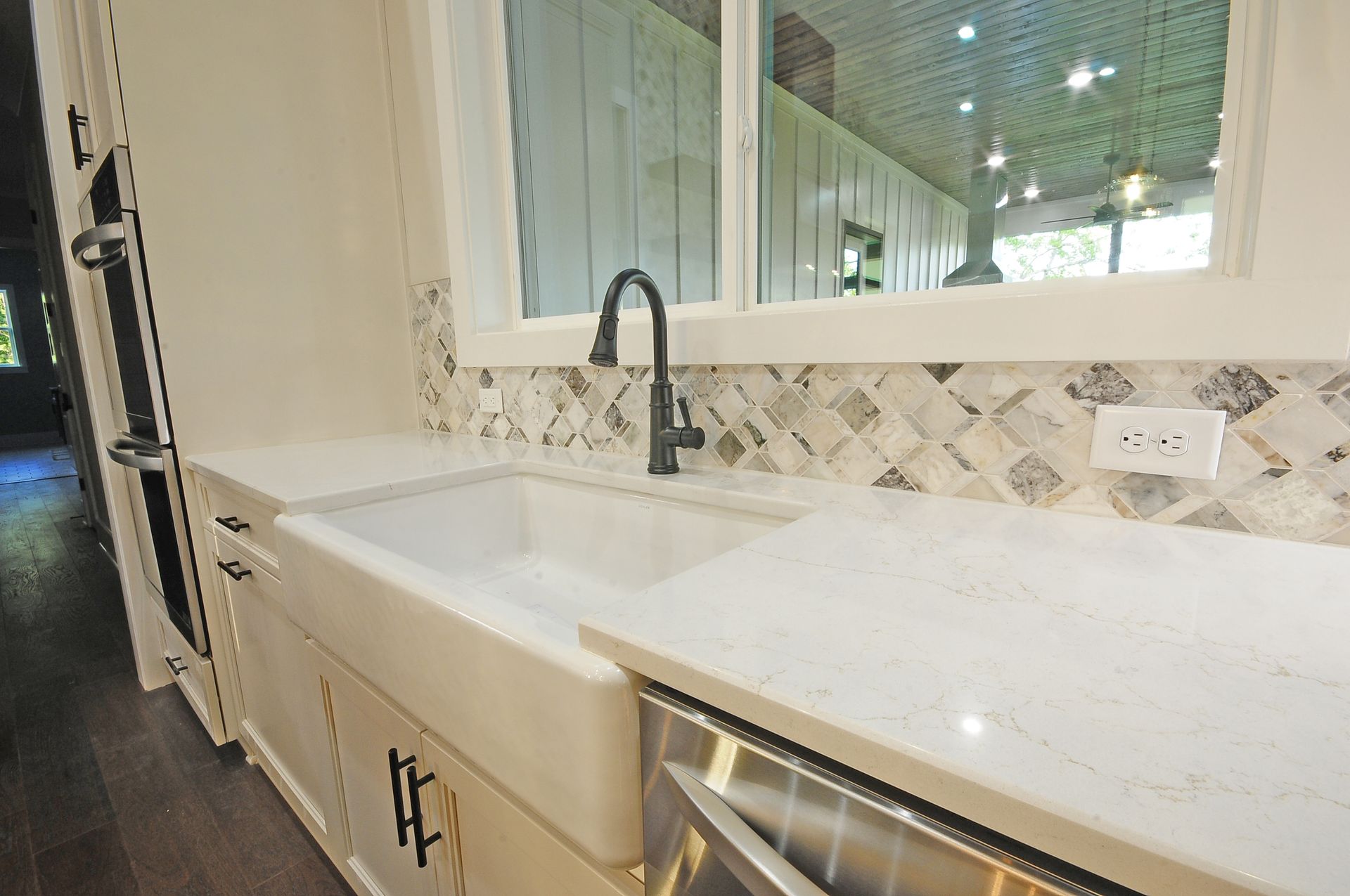 A kitchen with a large sink and a stainless steel dishwasher.
