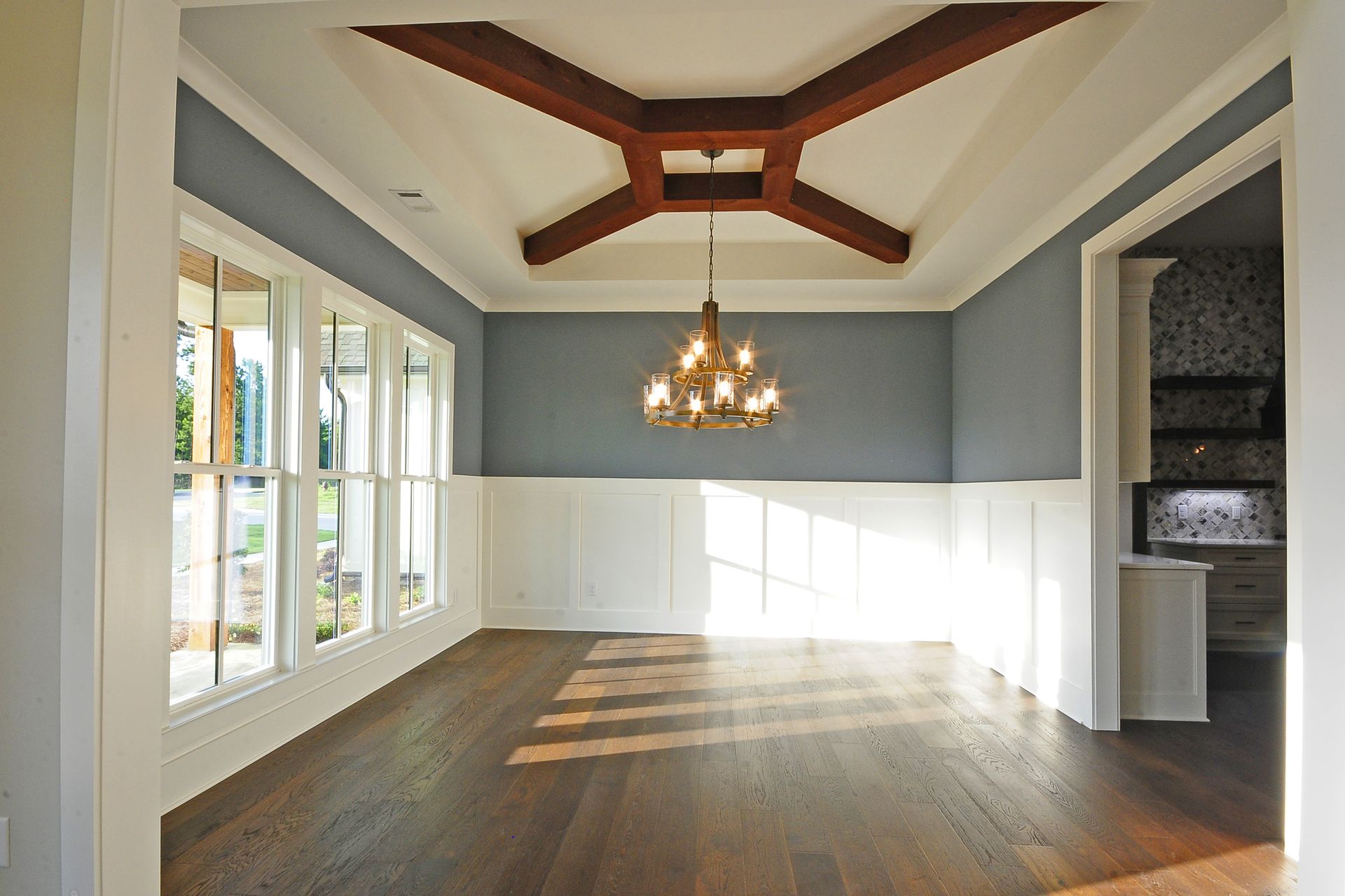 An empty dining room with a chandelier hanging from the ceiling