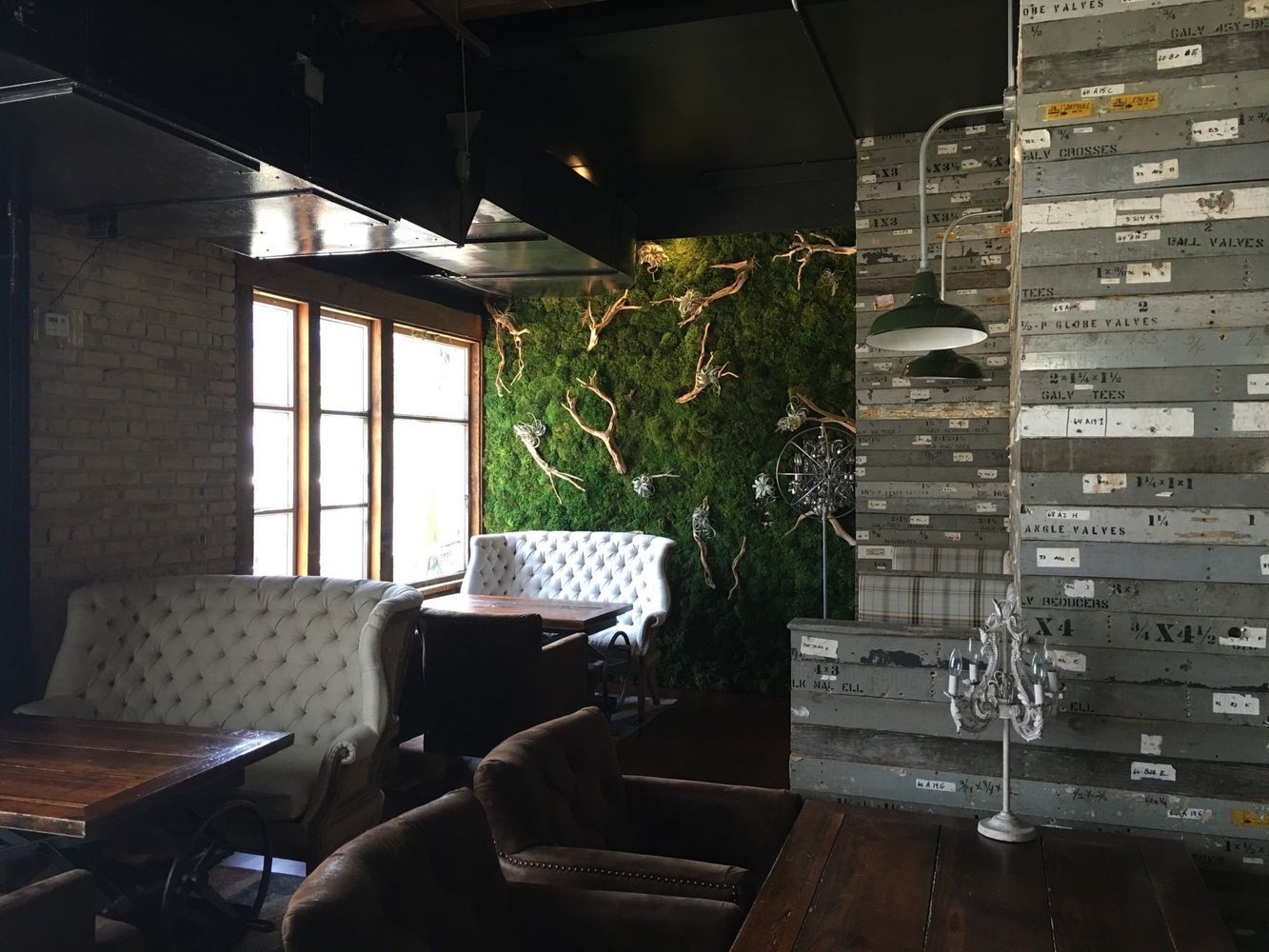 A restaurant with tables and chairs and a green wall