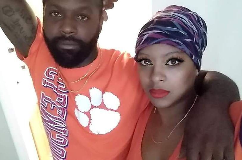 A man and a woman are posing for a picture and the man is wearing a clemson shirt