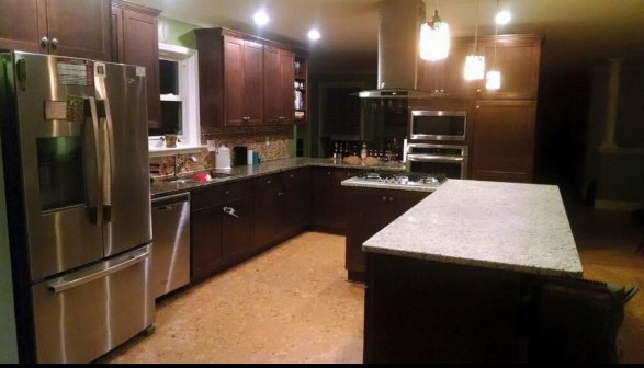 Dark-wood kitchen with stainless steel appliances, granite island, and pendant lights.
