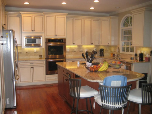 Kitchen with white cabinets, brown island, and stainless steel appliances.