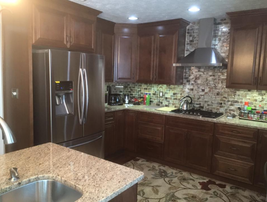 Kitchen with dark brown cabinets, stainless steel appliances, and patterned backsplash.