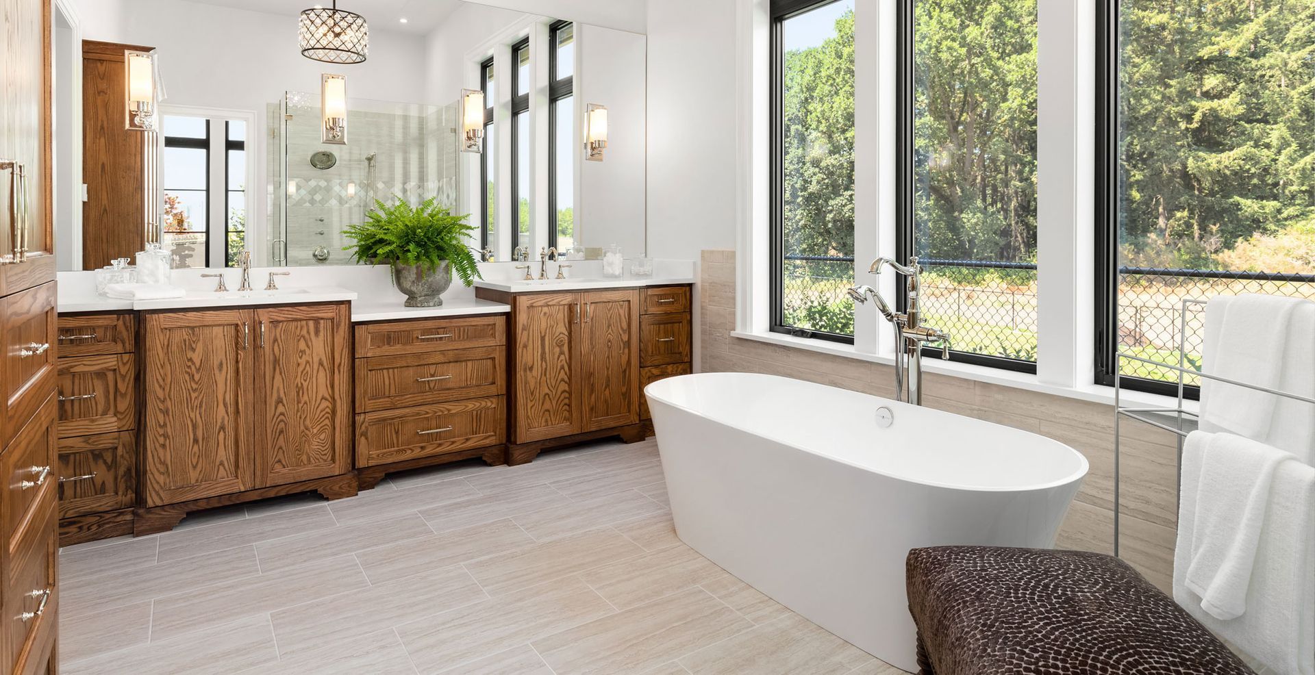 bathroom interior with dark hardwood cabinets, bathtub, and shower visible in mirror reflection