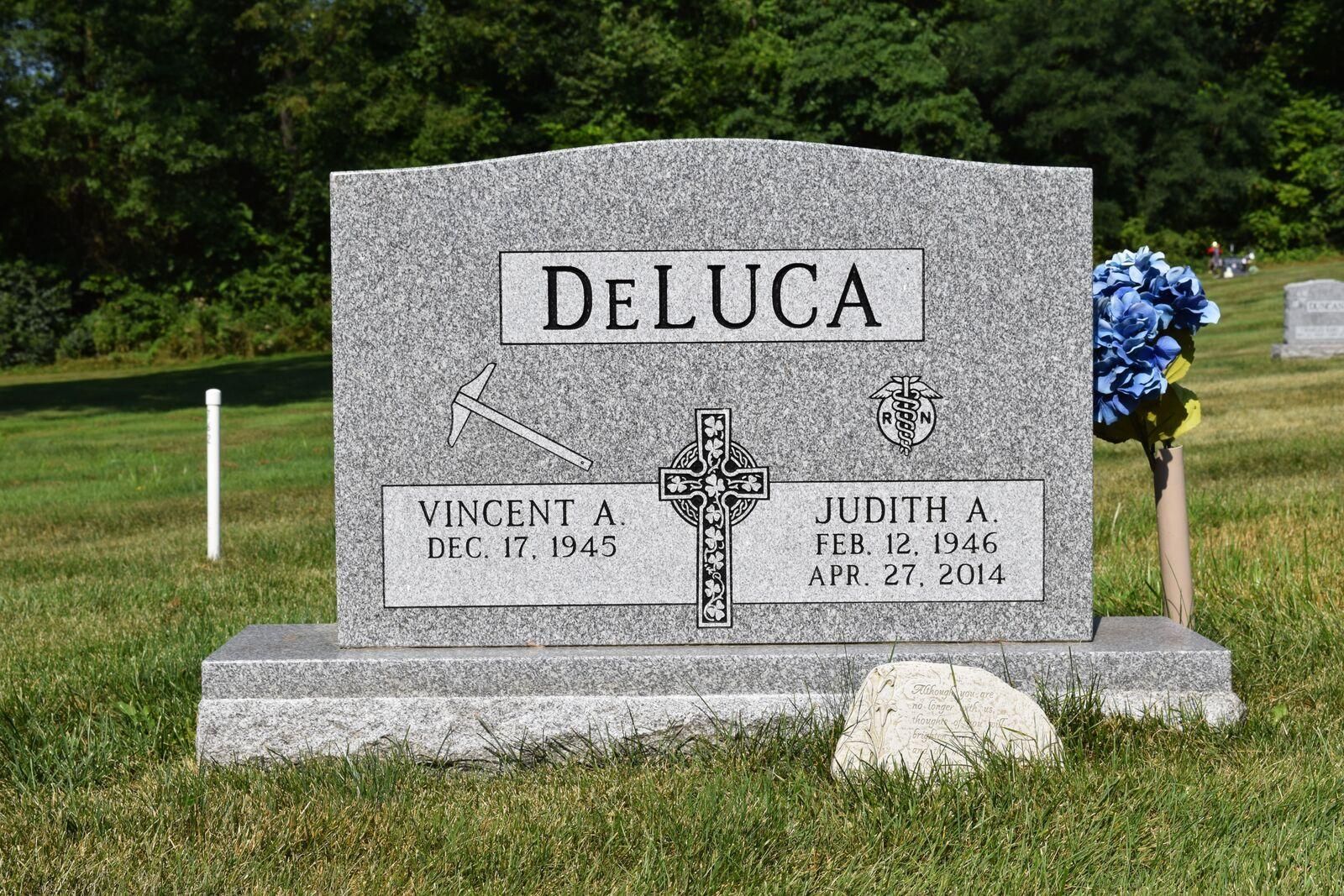 Gray granite tombstone; DELUCA family name; names Vincent and Judith with birth/death dates.
