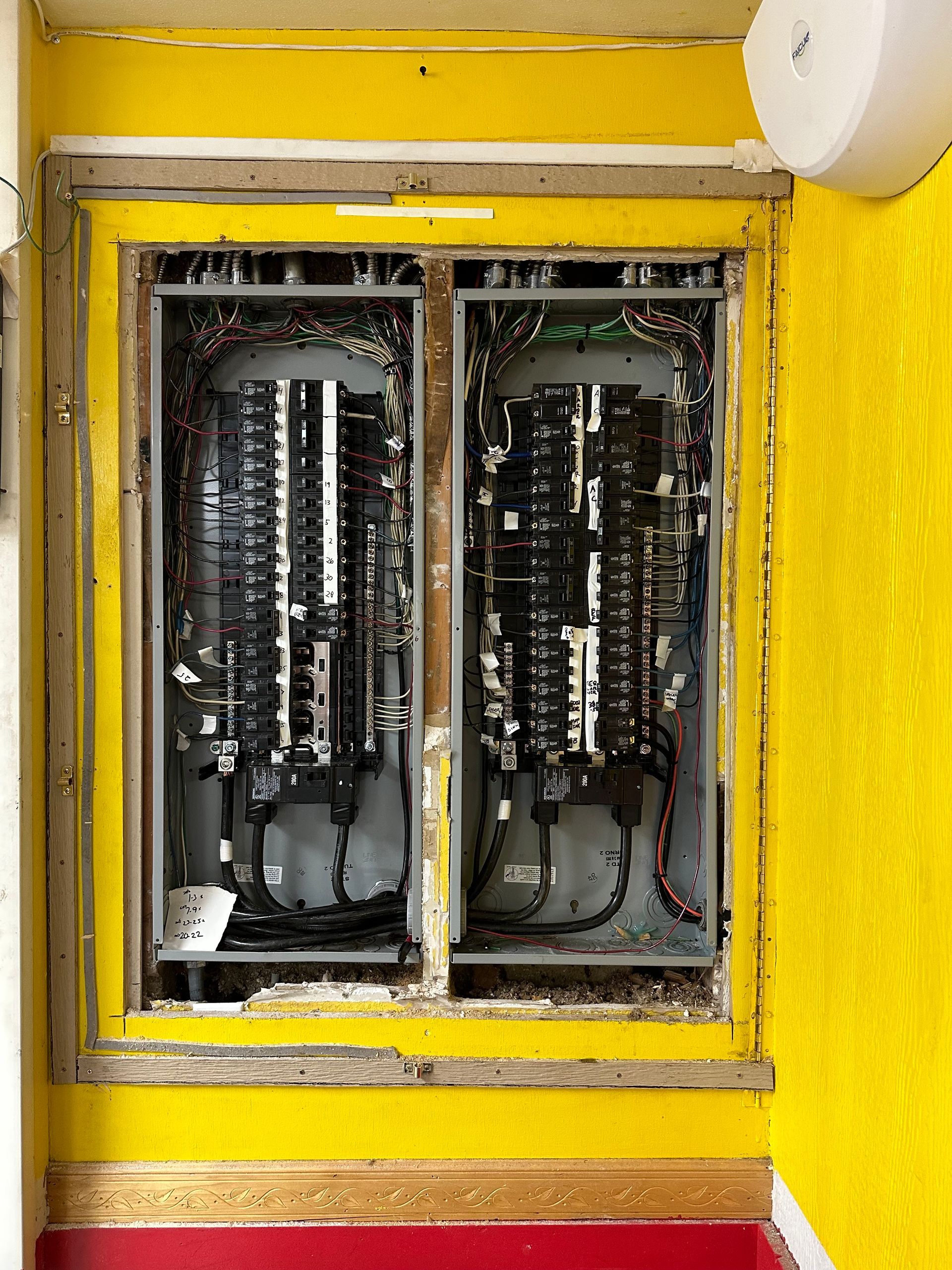 A yellow wall with a bunch of wires coming out of it.