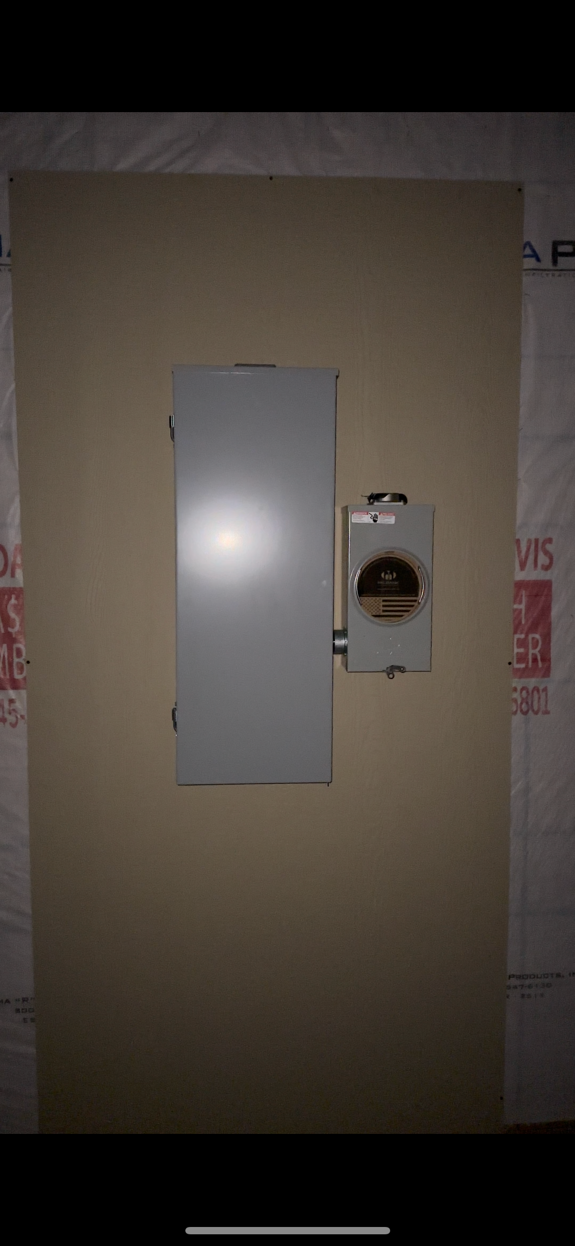 A wall with a door and a switch on it.