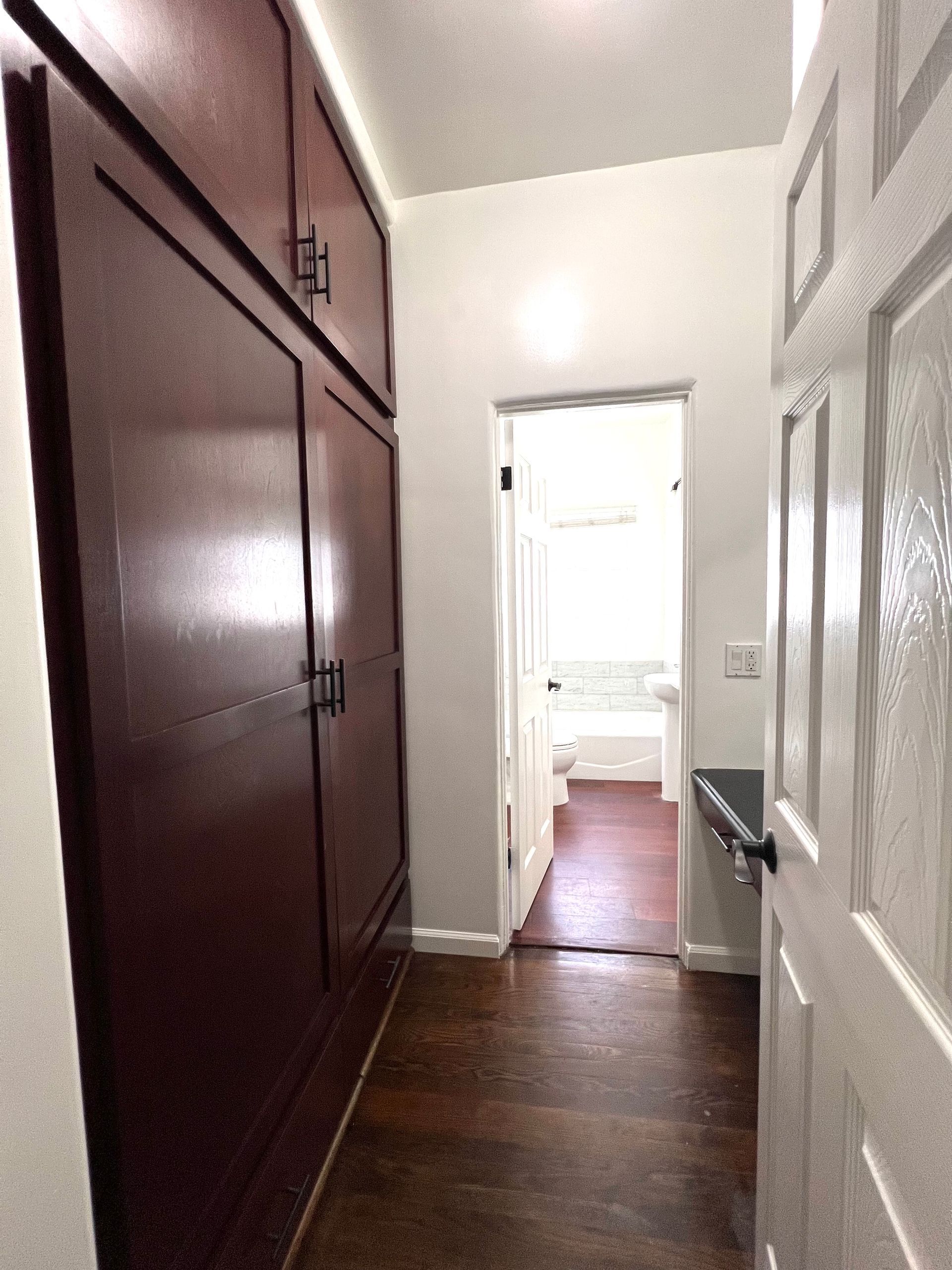 A hallway with a door that leads to a bathroom